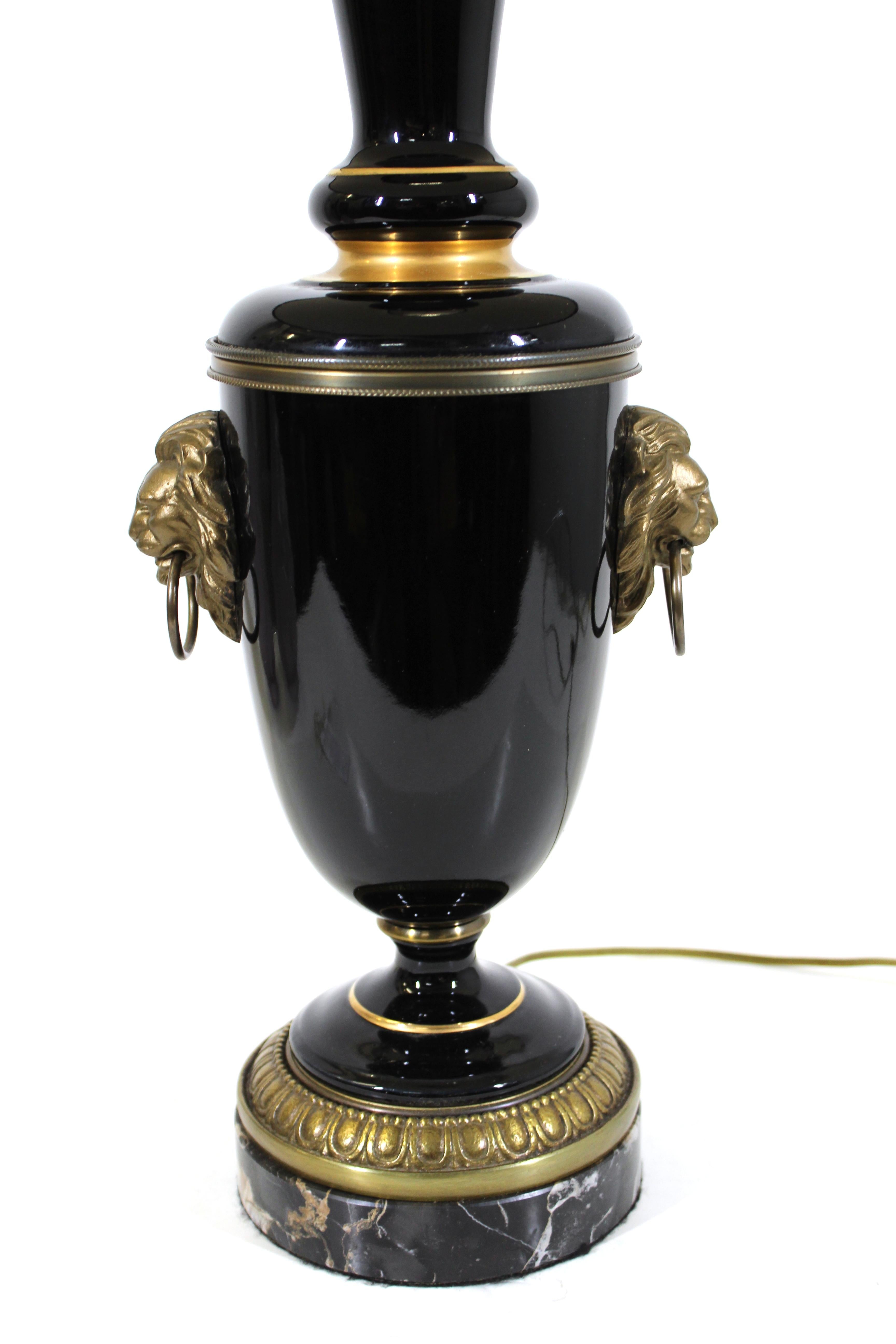 American Art Deco period table lamp in black glass with coordinating black shade. The lamp has a brass lion head on each side and a black base. Made in the USA during the 1930's, and recently rewired.