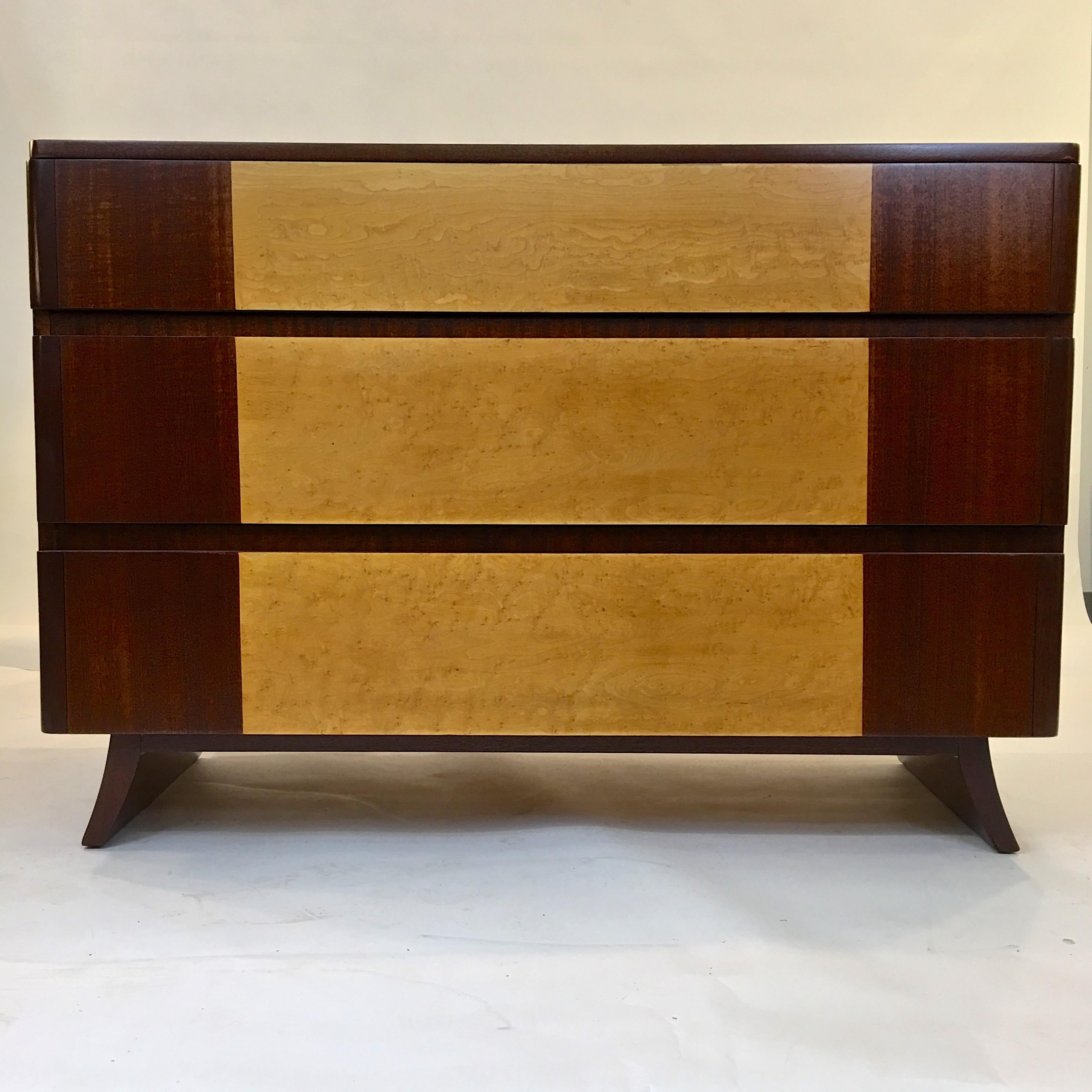 1940s American Art Deco chest of drawers with curved front edges on splayed legs by R-Way Furniture Co. in two-tone bookmatched mahogany and exotic burl elm inlay.
In the manner of Eliel Saarinen. Three commodious clean drawers. Invisible grooved