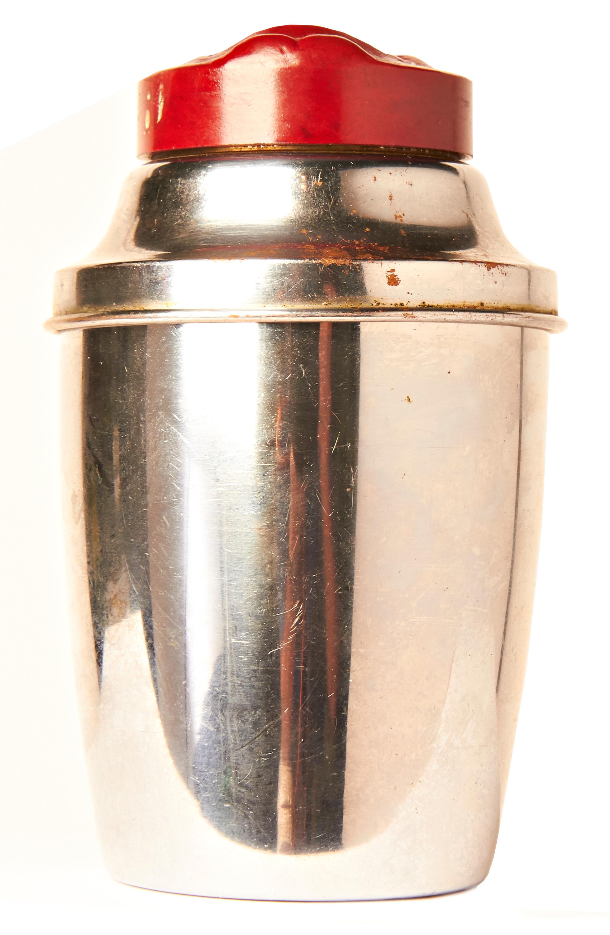 This amusing American Art Deco chrome-plated cocktail Shaker features a burgundy red Bakelite cap with a raised 