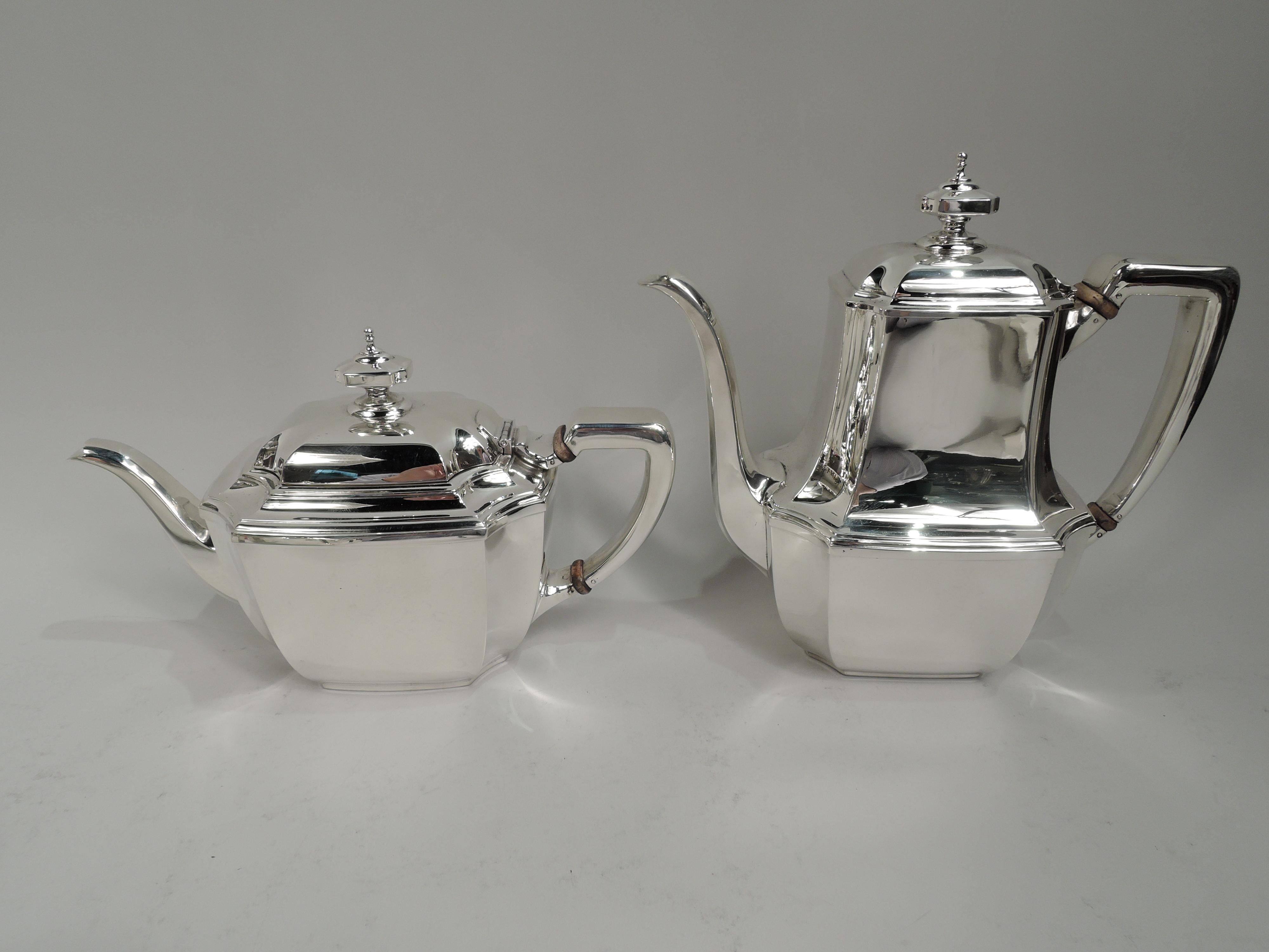 Hampton sterling silver coffee and tea set. Made by Tiffany & Co. in New York. This set comprises 5 pieces: Coffeepot, teapot, creamer, sugar, and waste bowl. Rectilinear with concave corners, and stepped rim. Covers stepped and concave with finial