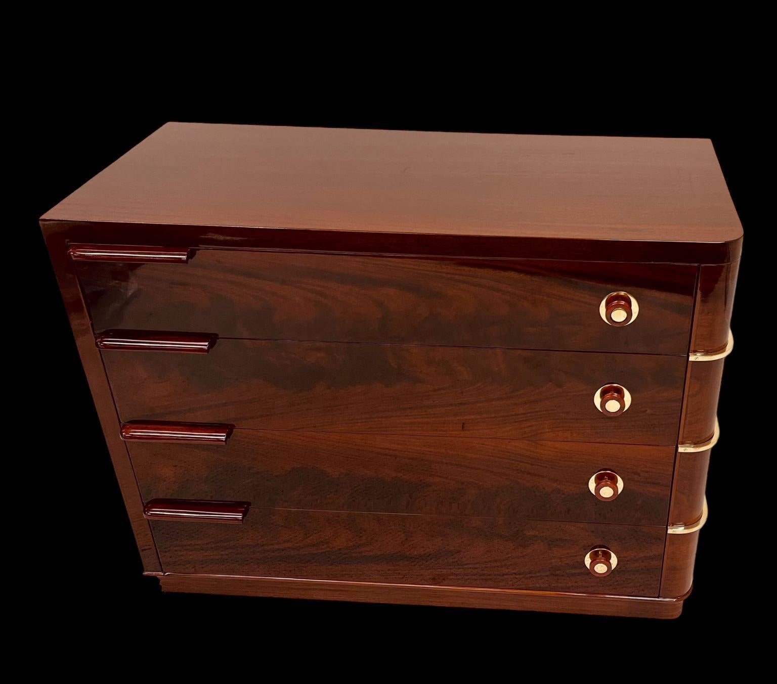 A magnificent example of an American Streamline Art Deco Flame Mahogany commode from the J.B VanSciver Furniture Company of Camden NJ. A fabulous four drawer book match Flame Mahogany chest with rare bakelite and hand polished brass handles. With