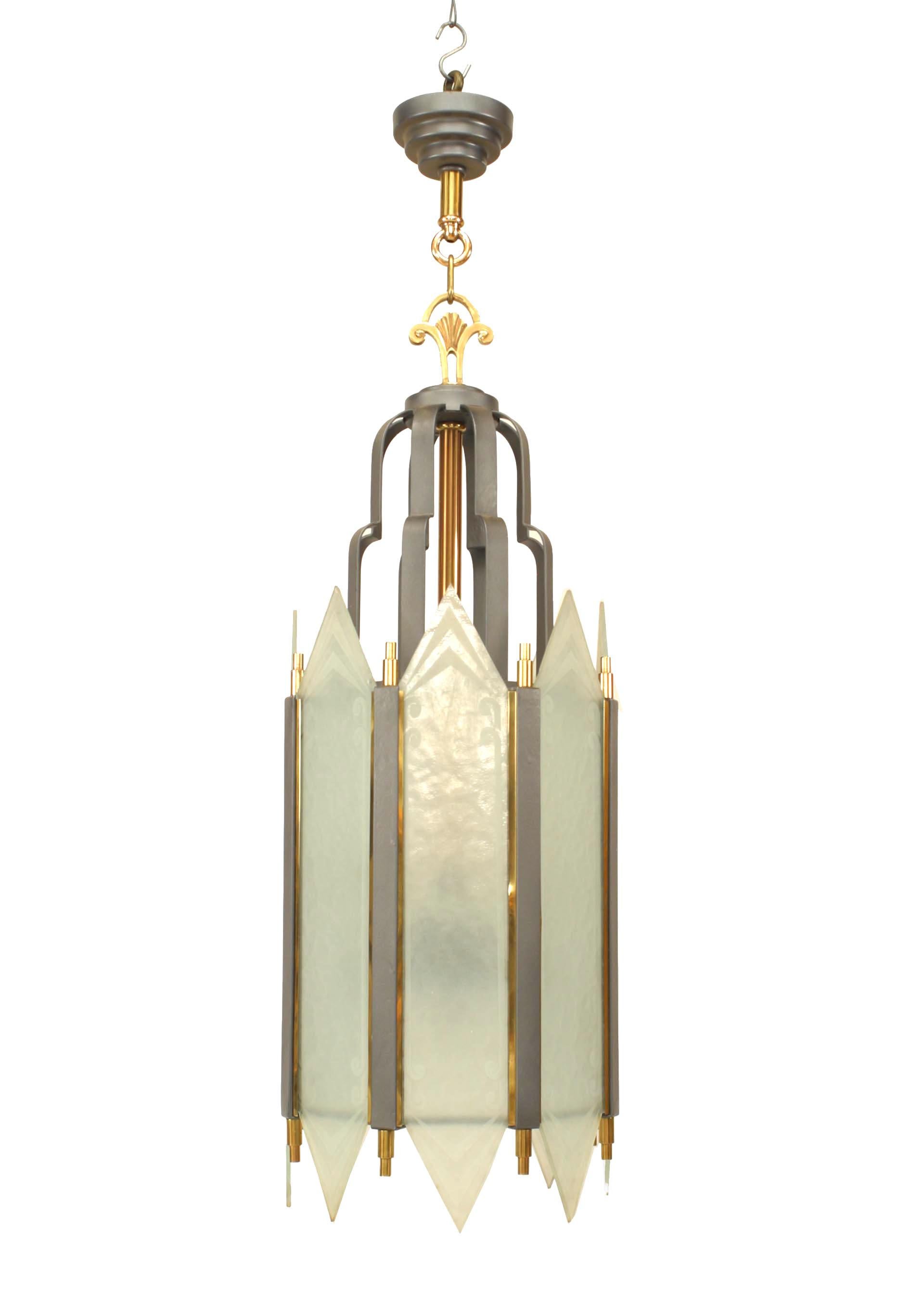American Art Deco iron cylindrical form lantern with 8 etched geometric and scroll design frosted glass panels separated with brass finials under a 2 tiered top extension.
