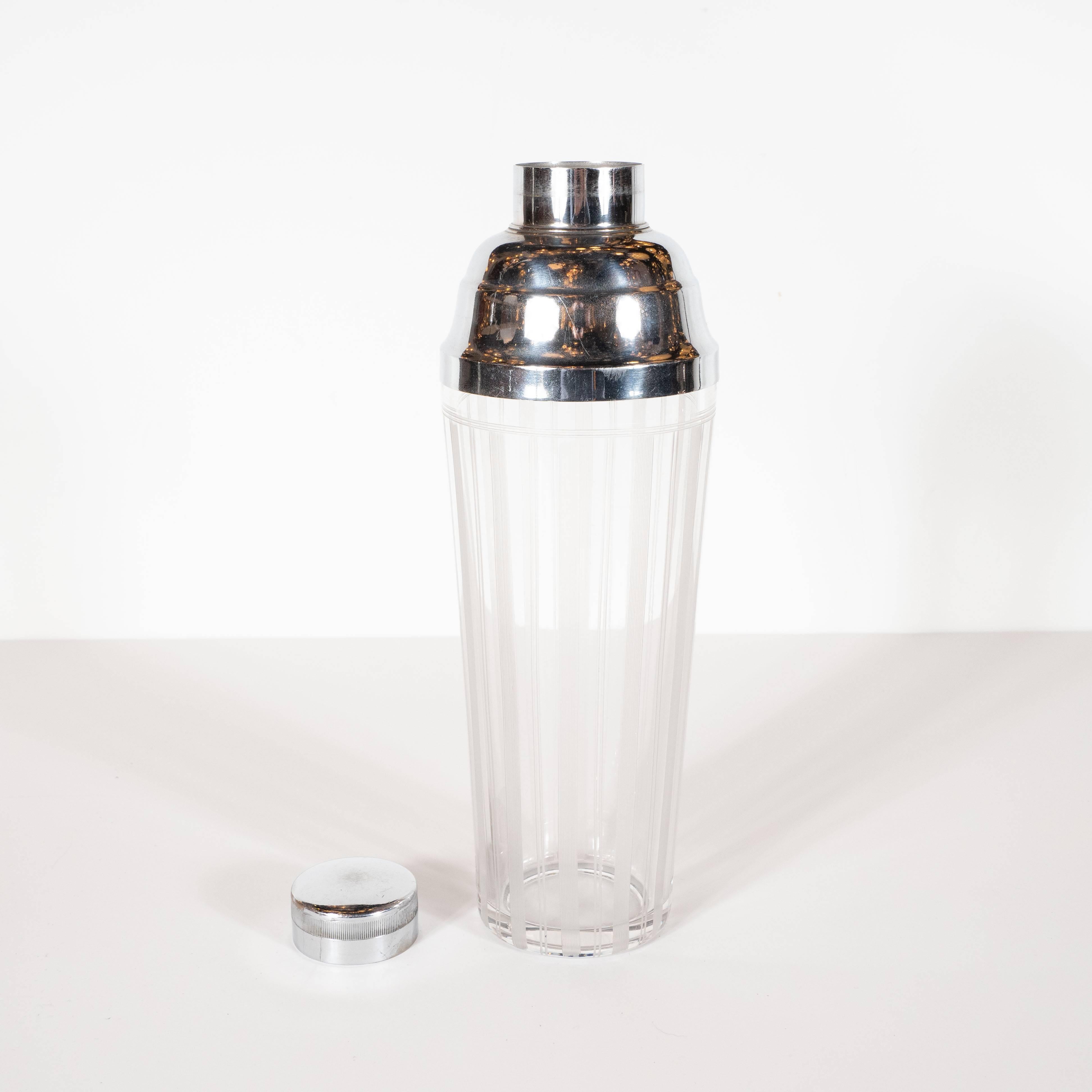 This sophisticated Art Deco cocktail shaker was realized in the United States, circa 1935. It features a gently expanding conical body with a wealth of etched vertical striations. These lines- alternating between pairs and striped bands- culminating