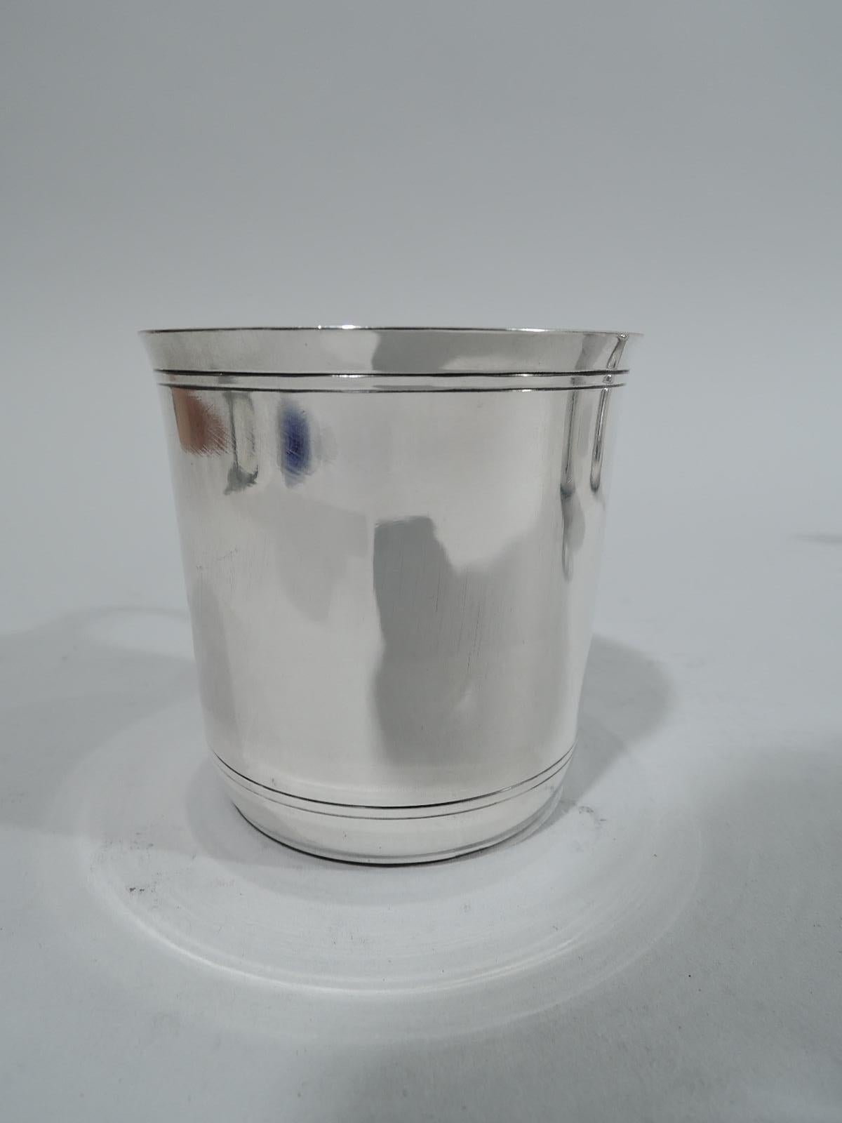 Art Deco sterling silver baby cup. Made by Tiffany & Co. in New York, circa 1941. Straight sides with flared rim and scroll bracket handle. Engraved double line borders at top and bottom leave plenty of room for a big-hearted presentation. Fully
