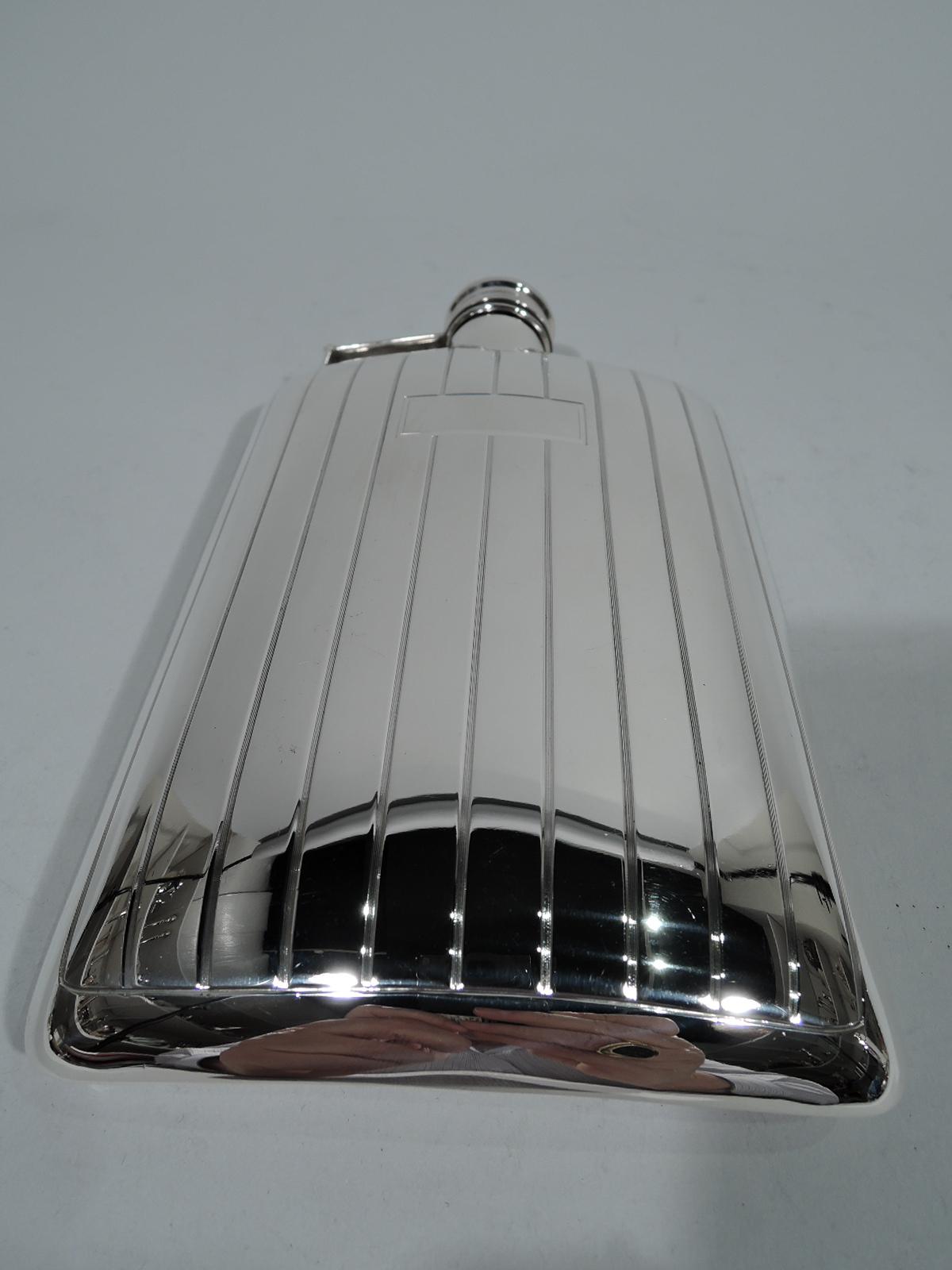 Art Deco sterling silver flask. Curved and rectangular body with hinged and cork-lined cover. Band has reeded lines alternating with wide and plain bands. Rectangular frame (vacant). Back plain. Marks includes maker’s stamp Meriden Britannia (part