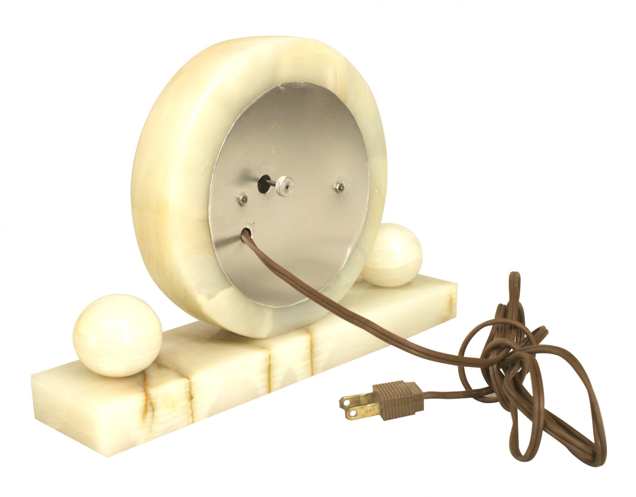 American Art Deco white onyx table clock with disc shaped form resting on a rectangular base and flanked by two balls. (Not working)