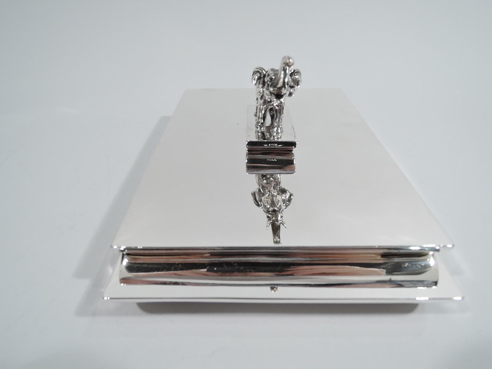 American Art Deco sterling silver box, circa 1930. Boat-form with straight sides and upturned ends. Hinged and inset cover same as is finial to which is mounted cast figure of an elephant, a joyful beast with upturned trunk and gaping mouth. Box