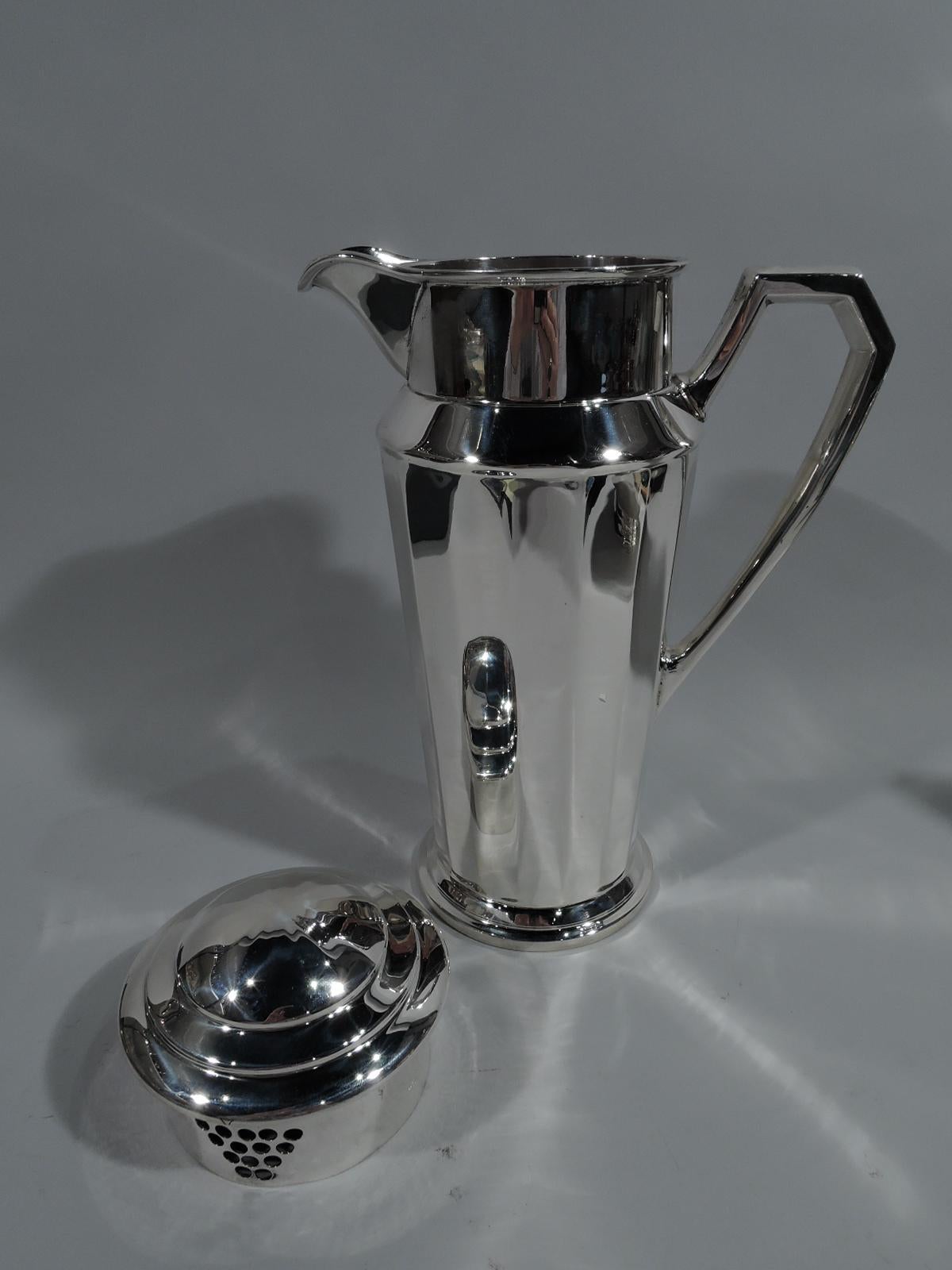 Art Deco sterling silver cocktail Shaker. Made by Frank W. Smith in Gardner, Mass, circa 1925. Tapering and faceted body on stepped foot. Canted shoulder and straight drum-form neck with large spout and built-in strainer, and faceted high-looping