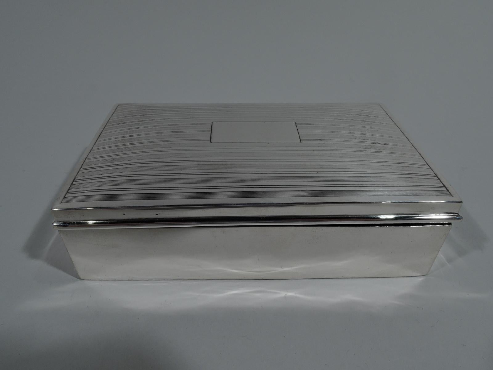 American Art Deco sterling silver keepsake box, circa 1920. Rectangular with straight sides. Cover hinged and gently curved with molded rim. Cover top has horizontal linear ornament with plain lines alternating with engine-turned ones, and central