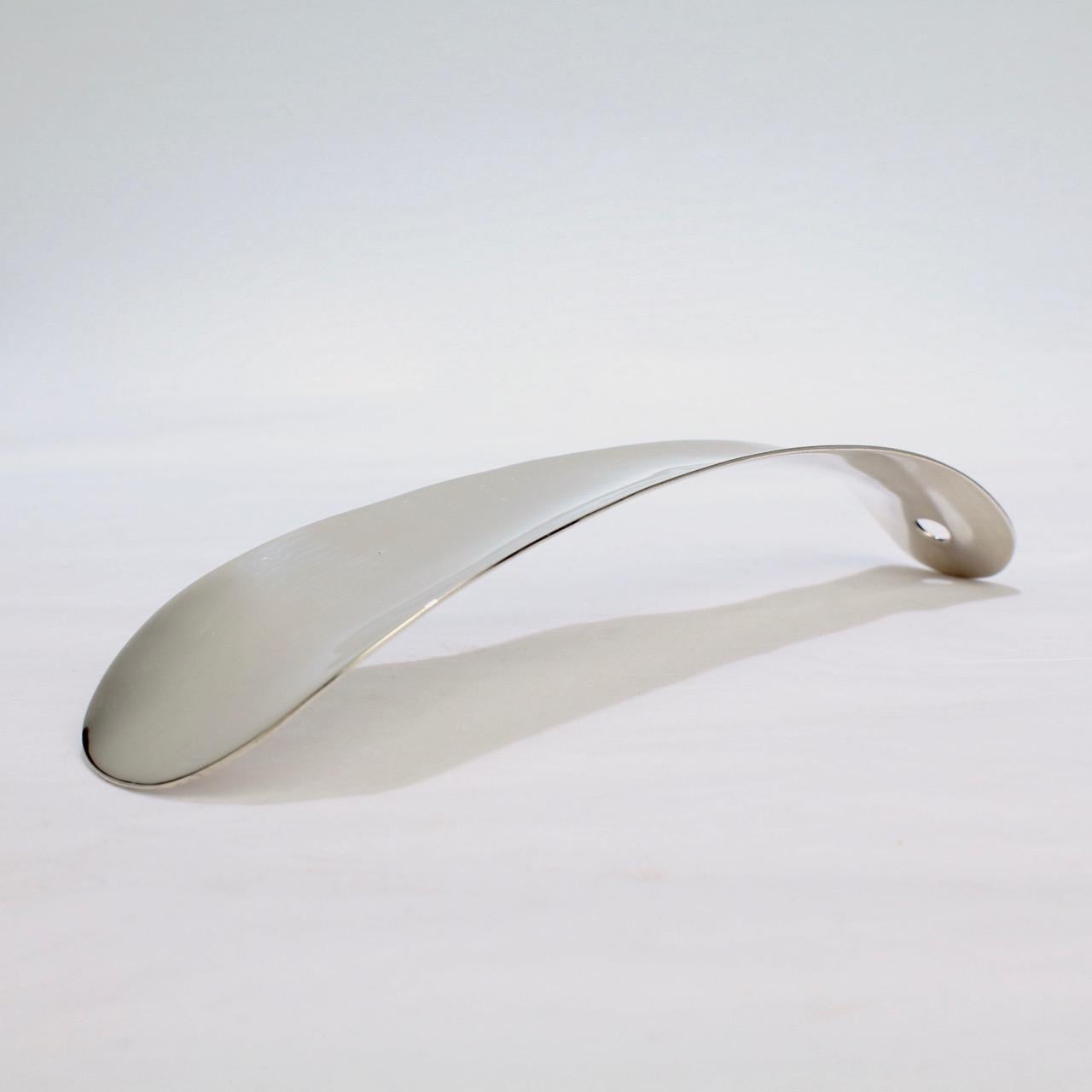 A sleek Art Deco sterling silver shoe horn.

Simple and streamlined, this thick-gauged shoe horn is a perfect example of 'Form meets Function'. 

Simply a sturdy accessory that is a pleasure to use!

The reverse is marked for the Roger Williams
