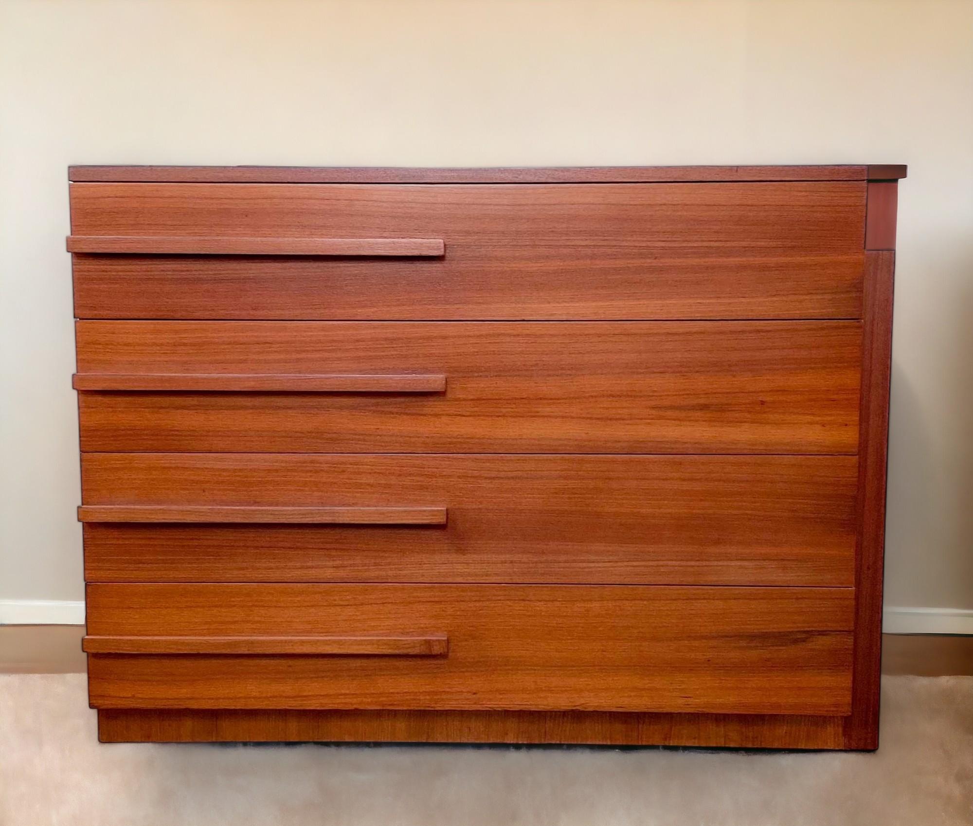 Commode Streamline à quatre tiroirs en acajou de la Modernage Furniture Company de New York, datant des années 1930. 
Le socle en retrait se poursuit sous la forme d'un panneau surélevé le long du côté droit du meuble et se termine à mi-chemin sur