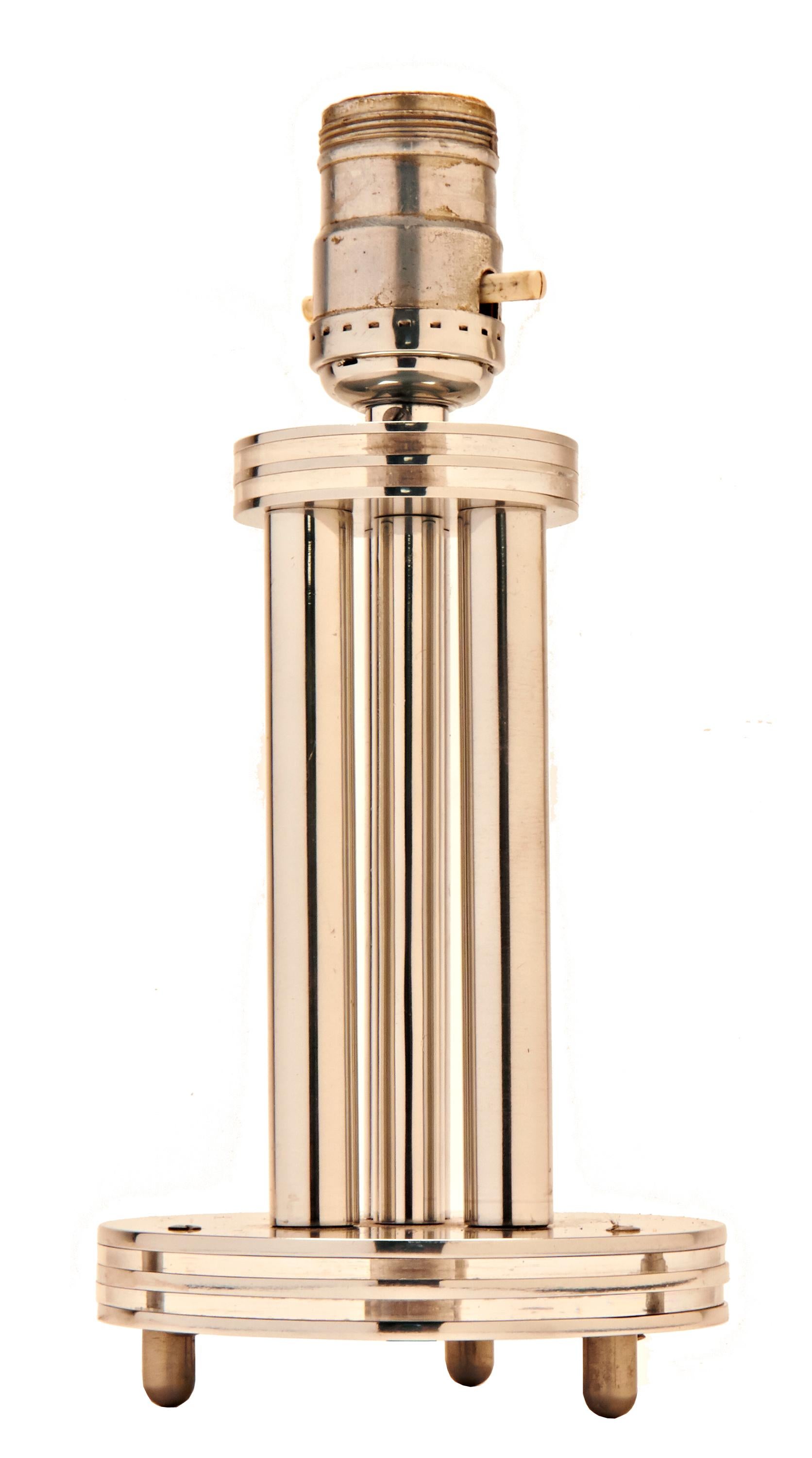 The body of this beautiful and architecturally designed American Art Deco/ Machine Age accent lamp is constructed from a circular base and cap each constructed from three disks of high polished aluminum that sandwich two disks of clear Lucite.