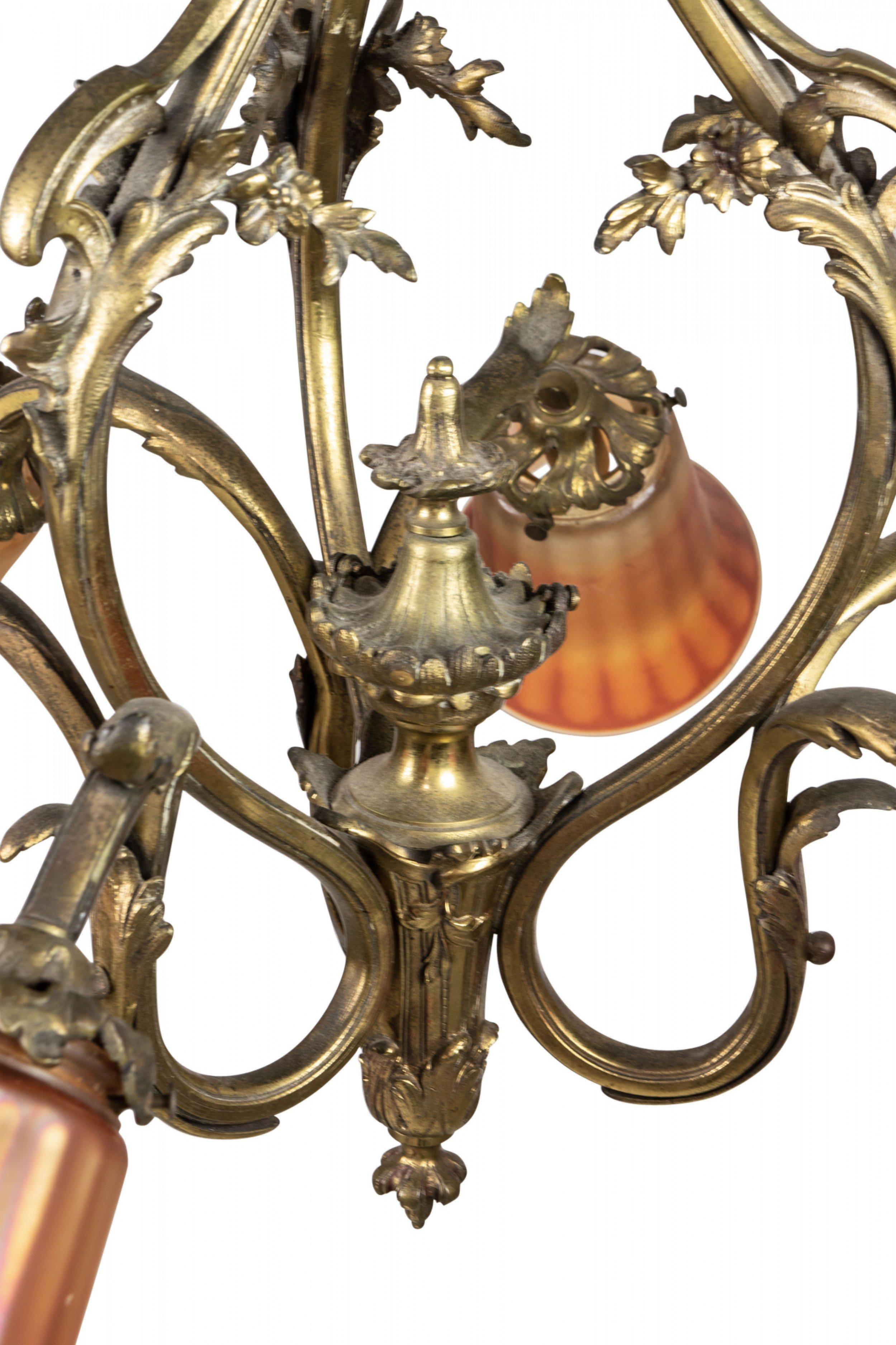 American Art Nouveau bronze 6 arm chandelier with a floral motif and 6 fluted orange and purple carnival glass shades / globes.