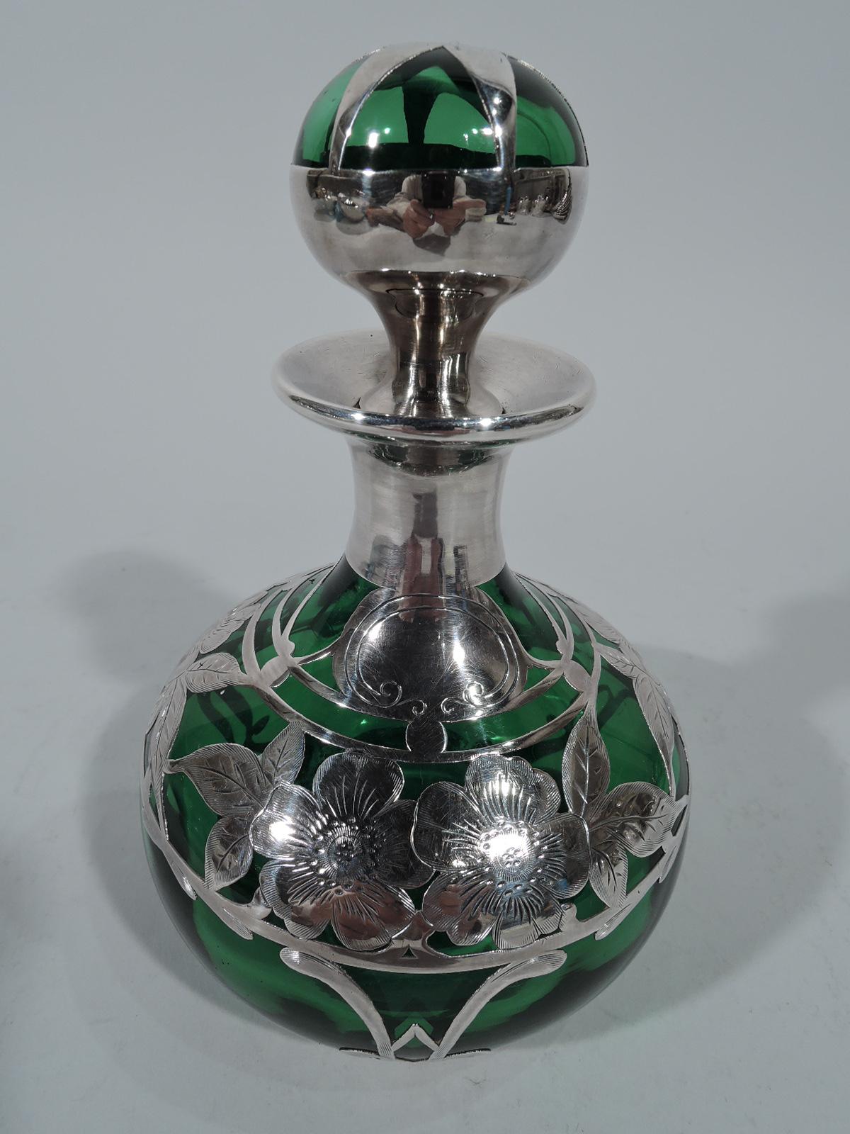 American Art Nouveau emerald glass perfume with silver overlay. Globular body with short neck and everted rim. Ball stopper with short plug. Engraved overlay in form of concentric bands inset with flowers. Scrolled cartouche (vacant). Stopper top