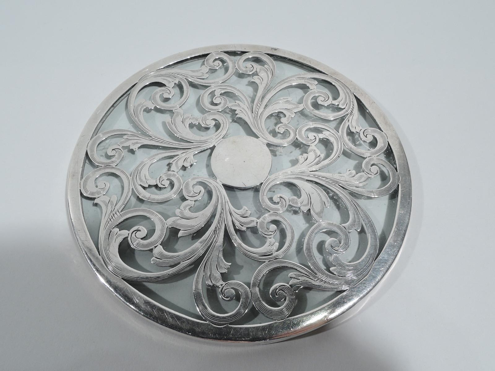 Art Nouveau glass trivet with engraved silver overlay. Round. Overlay in form of lush leafy scrolls. Central circle (vacant). Glass is clear. Marks include no. A92S and stamp for The Merrill Shops, a New York retailer active in the late 19th and