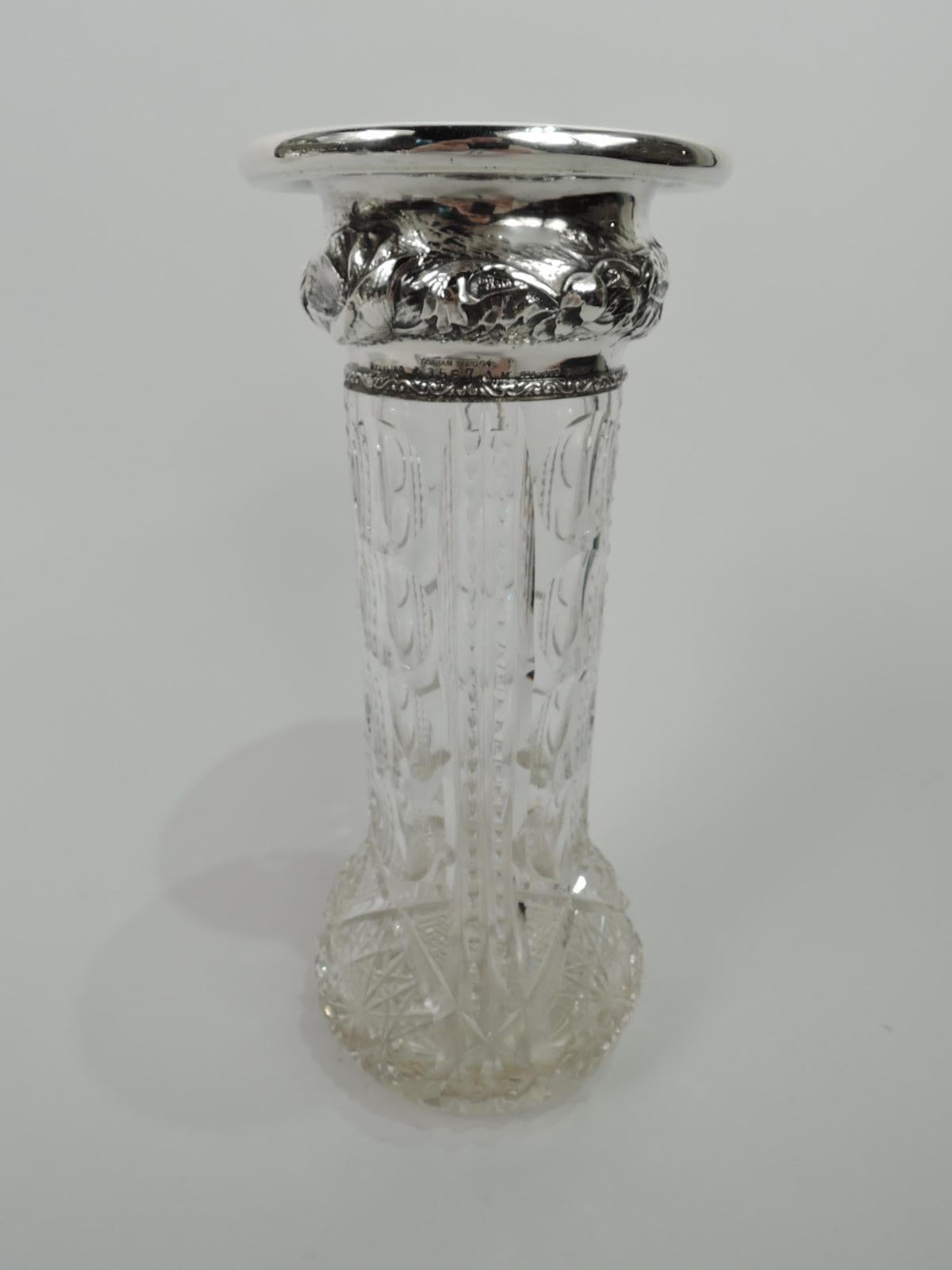 Turn-of-the-century American Art Nouveau brilliant-cut glass vase with sterling silver collar. Cylindrical with vertical ornament comprising two notched flutes between plain ones alternating with 4 circles. Bulbous bottom with stars and diaper.