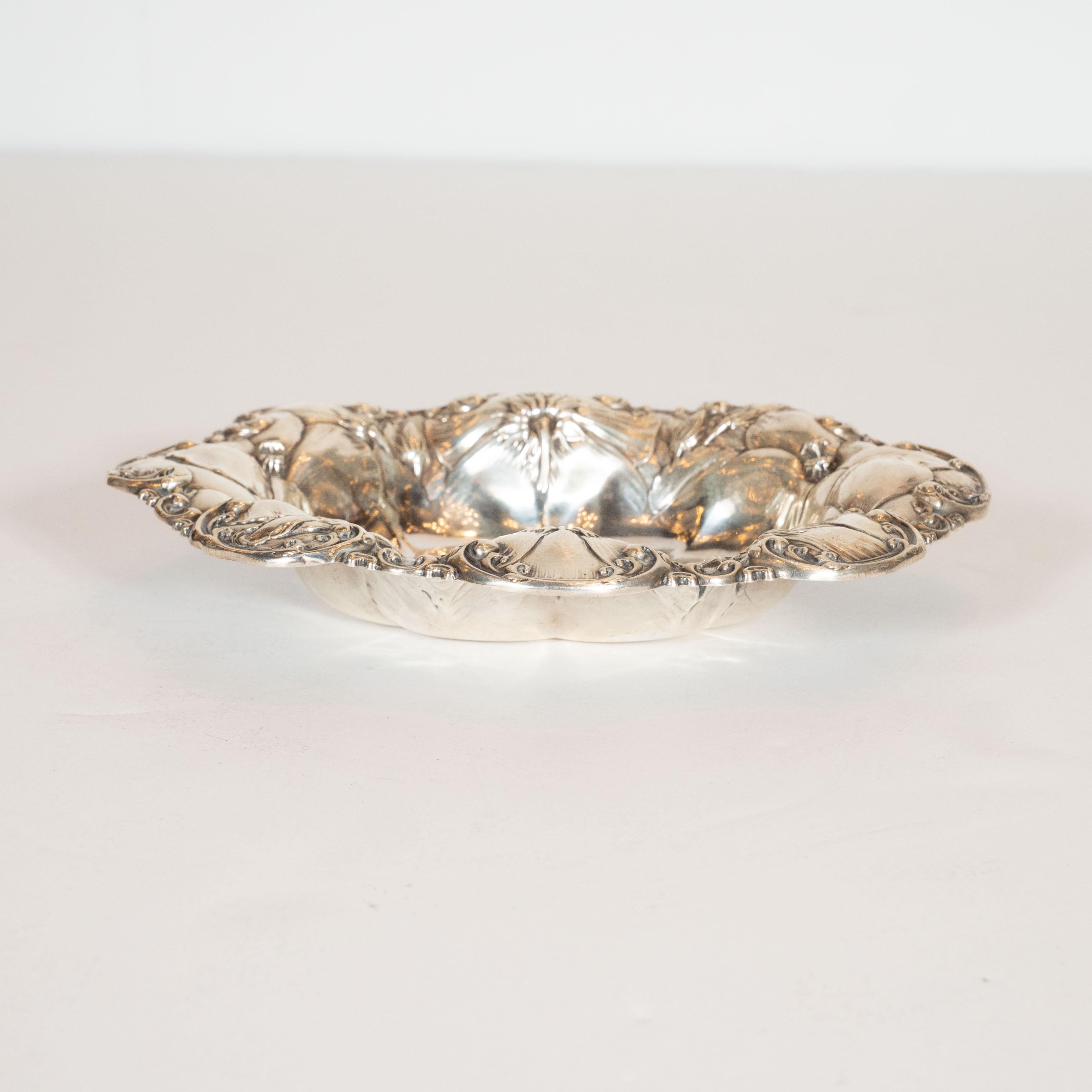 This elegant Art Nouveau sterling decorative dish was realized in the United States circa 1900. It features repousse stylized floral motifs, apparently morning glory flowers and abstract curvilinear scrolling forms hand-hammered into the oval