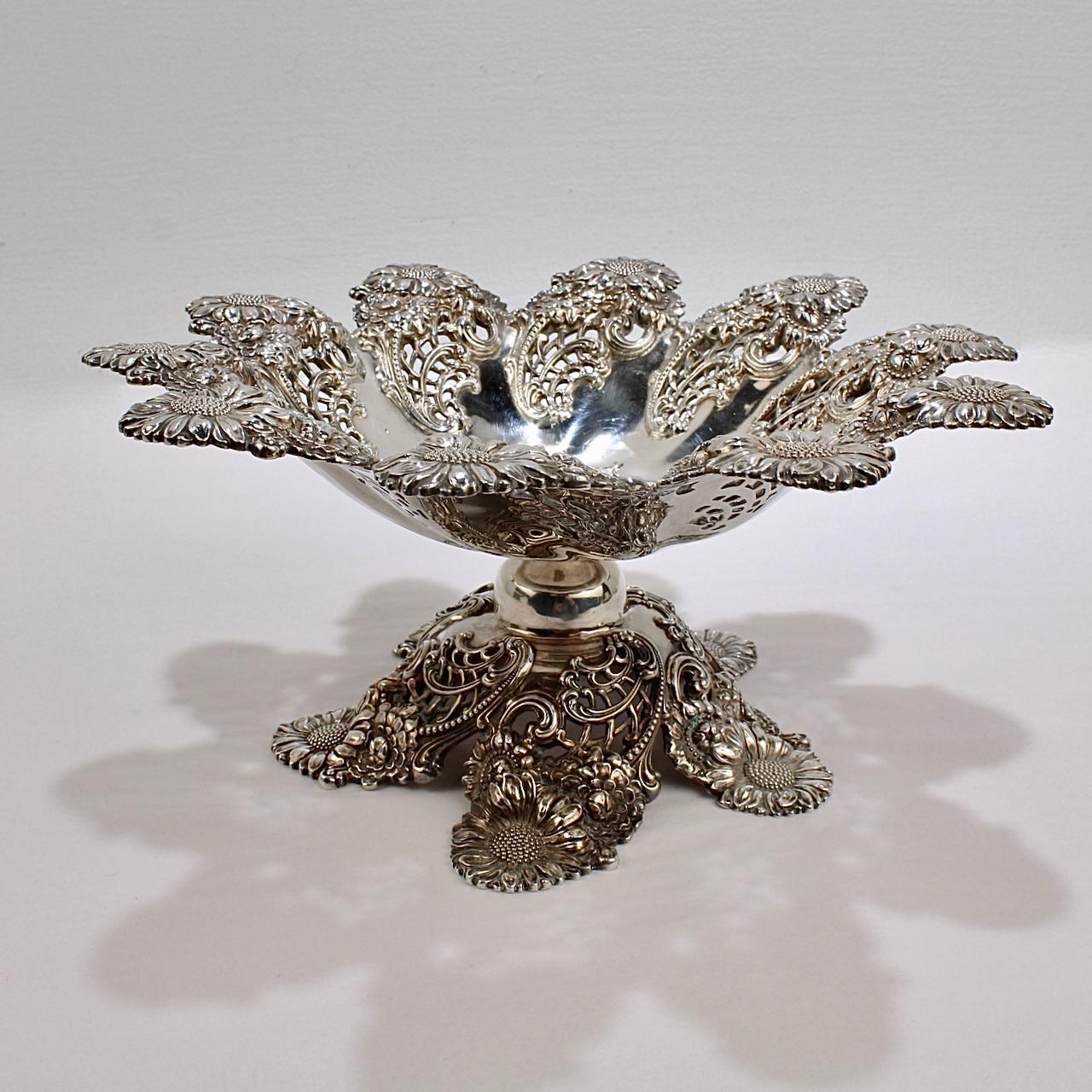A very fine American Art Nouveau floral repoussé footed bowl or compote.

In sterling silver by Dominick and Haff.

With a pierced, repeating border of sunflowers, chrysanthemums, and poppies that is repeated on a conforming foot.

Simply a
