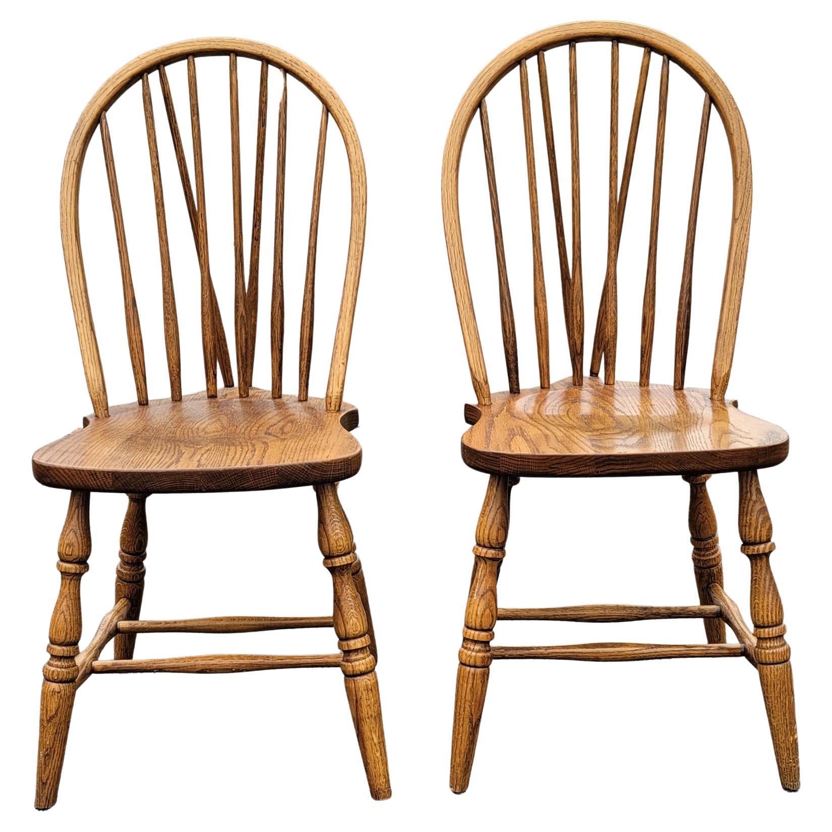 A beautiful pair of Arts & Crafts American oak fiddleback windsor chairs in great vintage condition. Chairs measure 17.5