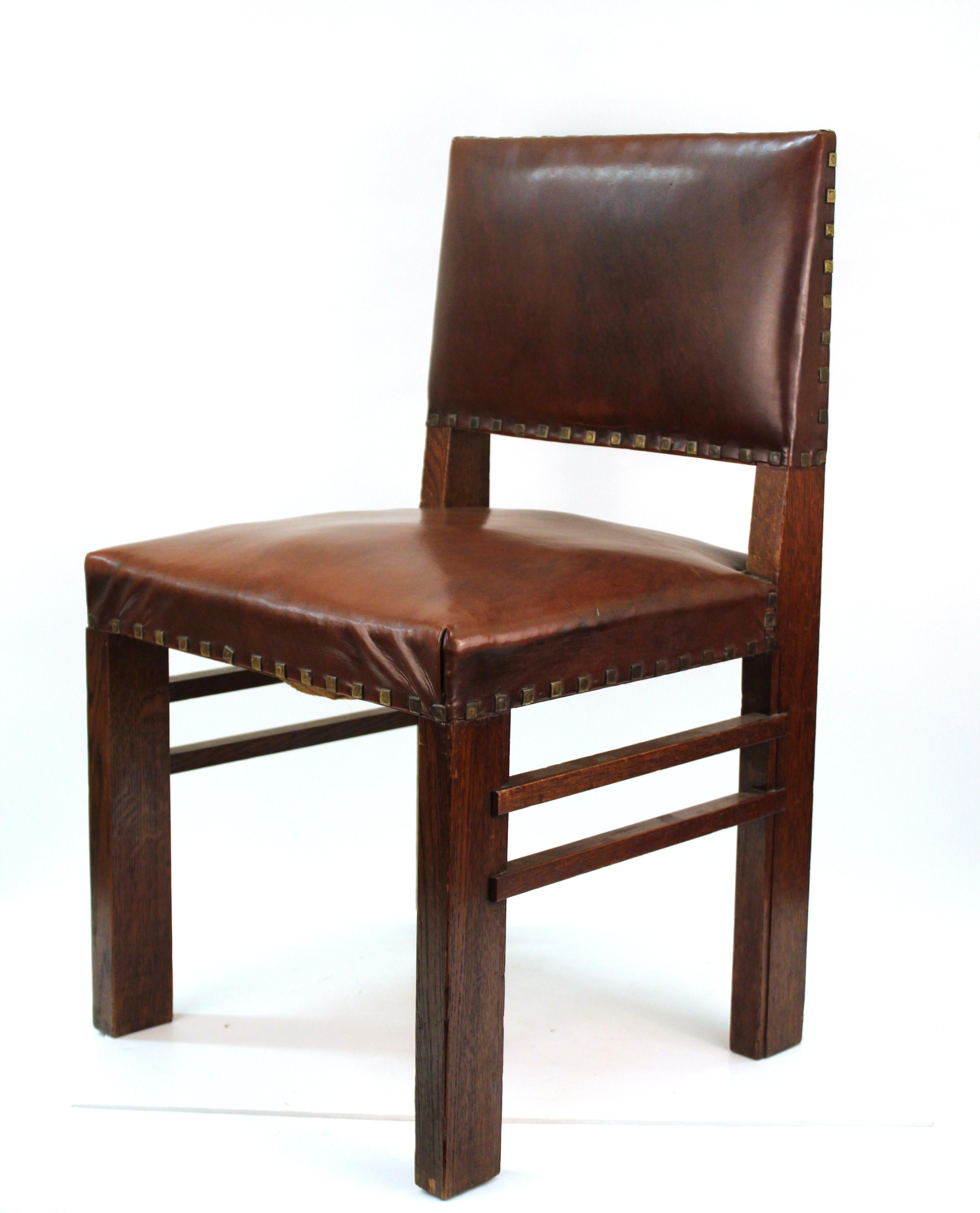 Set of dining chairs in oakwood and cognac colored leatherette seats and backs. Made in the United States during the 1910s, with one of the leatherette seats replaced. Some age-appropriate wear and use to the wood, with one chair having a minor loss