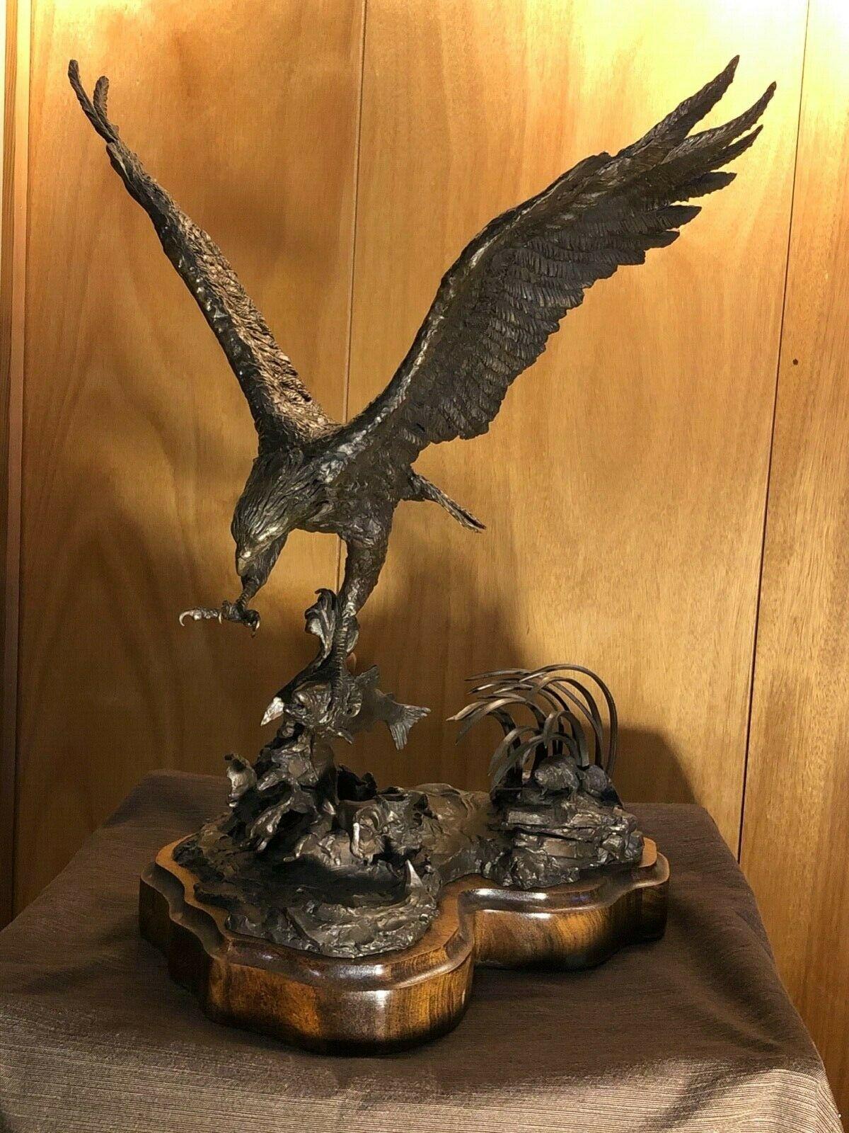 This is a stunning American eagle bronze by deceased American sculptor Lorenzo E. Ghiglieri (Oregon, B 1931, D 2020).

The bronze features a magnificent bald eagle catching a fish while in flight and is inscribed by the artist. dated 1976,