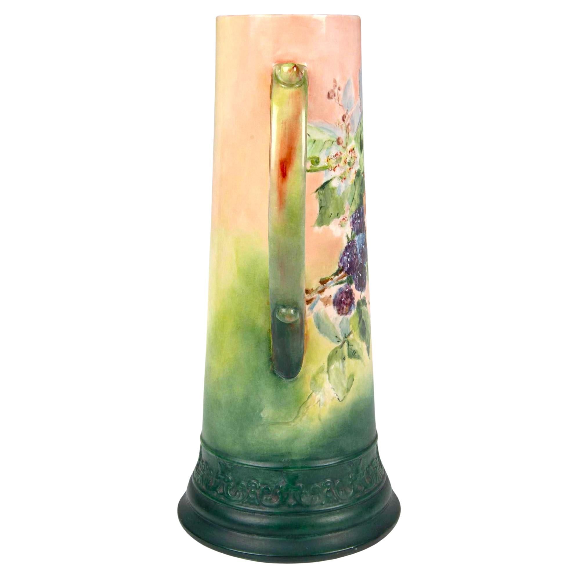 Experience the beauty and elegance of this early 20th-century North American white porcelain tankard from Belleek. This stunning piece is meticulously crafted and hand-painted with vibrant green and grapes detail, bringing a touch of nature's charm