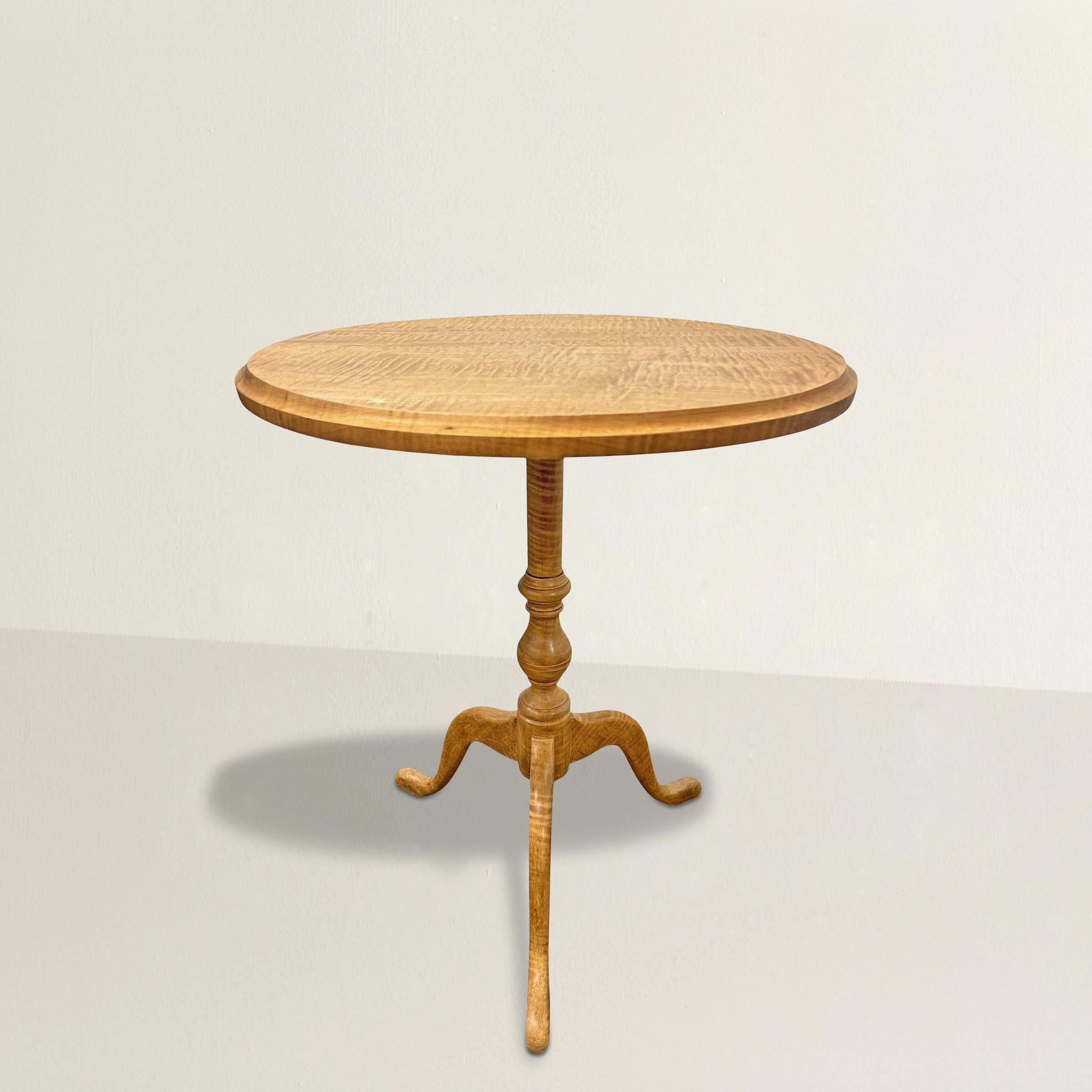 A modern piece with an old soul, this 21st-century American bench-made table takes its cues from the elegance of English Queen Anne design. Crafted entirely from tiger maple, its round top glows with the rippling flame of the wood’s grain—a honeyed
