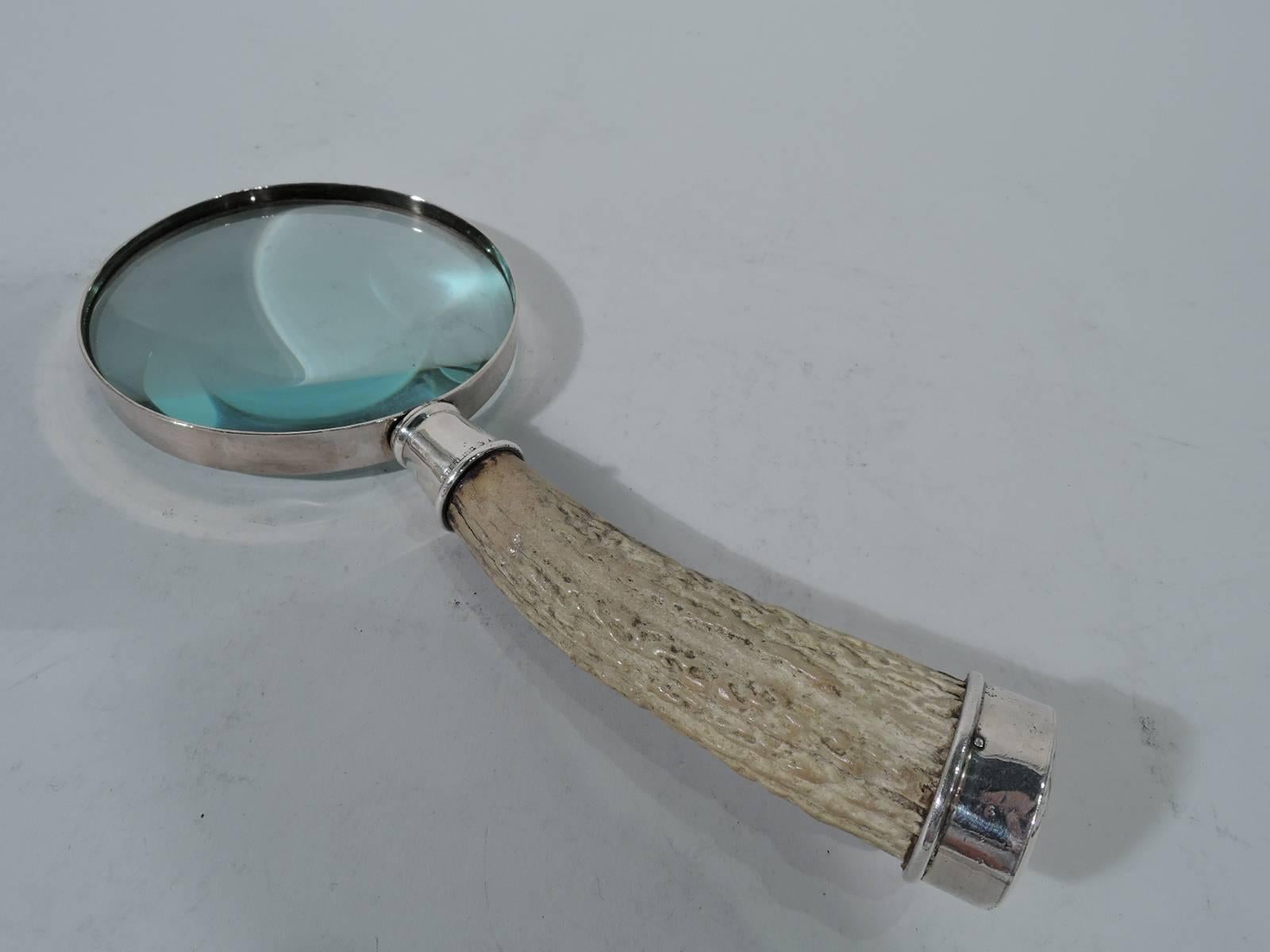 Big game-era sterling silver magnifying glass with horn handle. Circular and framed lens mounted to curved horn handle with sterling silver mounts (end mount vacant). Tactile easy-grip texture. A great period piece for the alpha in your life.