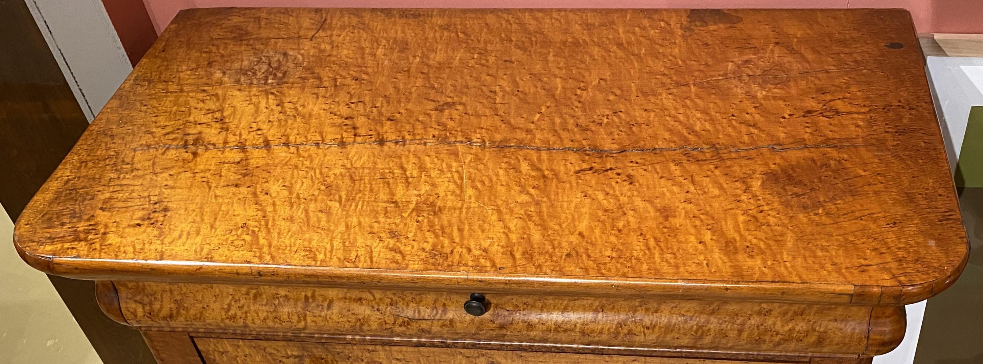 A fine example of a birds eye maple veneer Empire chest with rectangular top with curved front corners surmounting a shaped frieze drawer over three graduated drawers, all supported by nicely carved splayed feet. The chest is in American in origin,