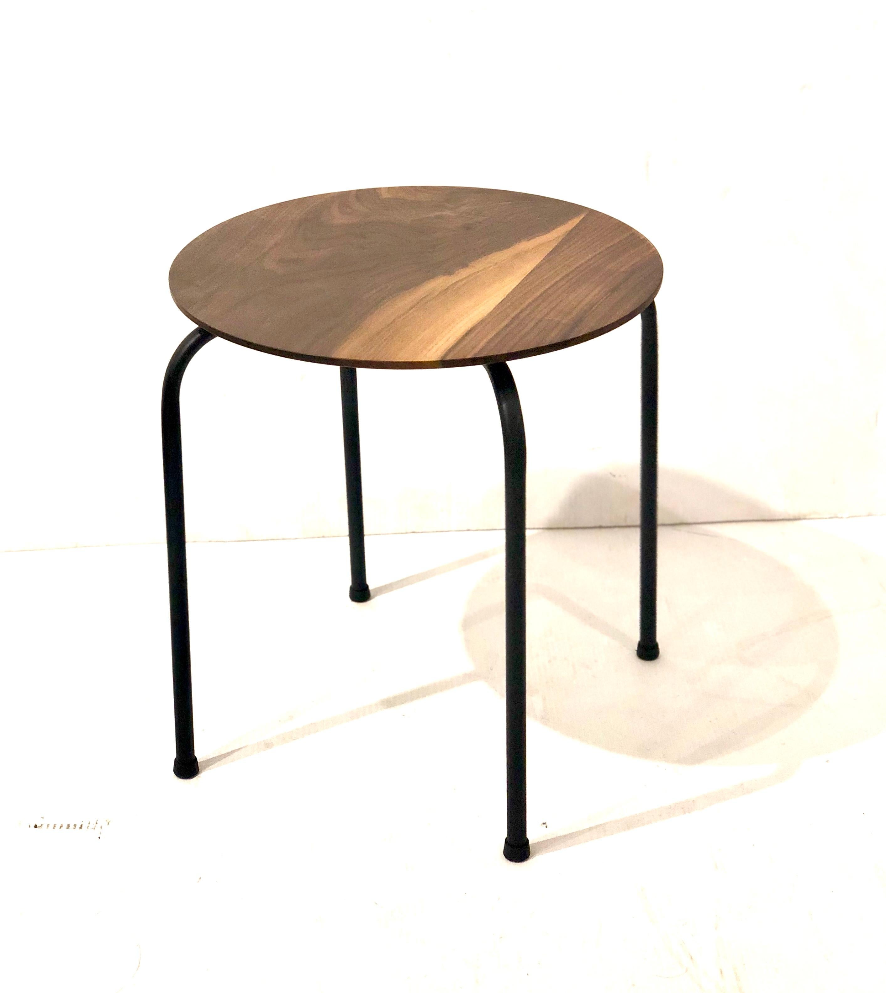 Simple elegant solid beveled walnut round top, cocktail table with black metal painted iron legs and plastic feet, circa 1970s. The table has been refinished and repainted it can be used as a stool or table.