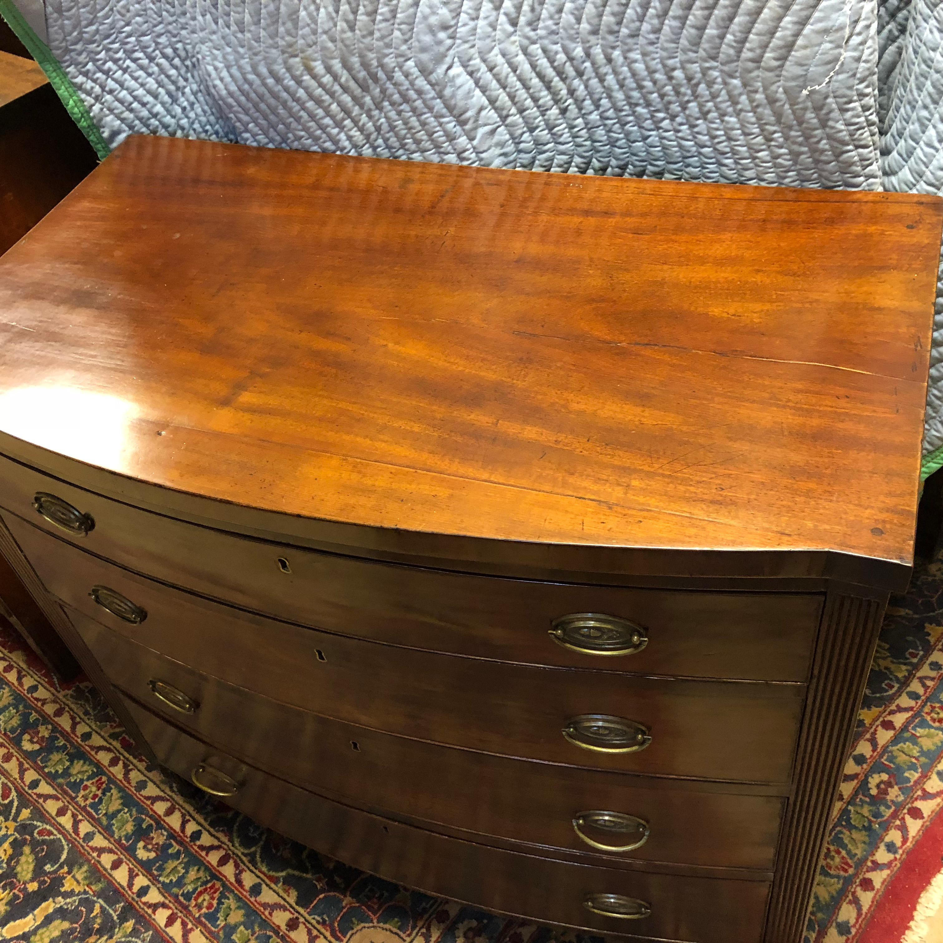 American bow front chest with crotched mahogany drawers, delicate reeding on each side, great finish, period brass pulls and handles, original turned fancy feet, poplar and pine lined. Very traditional and showy.