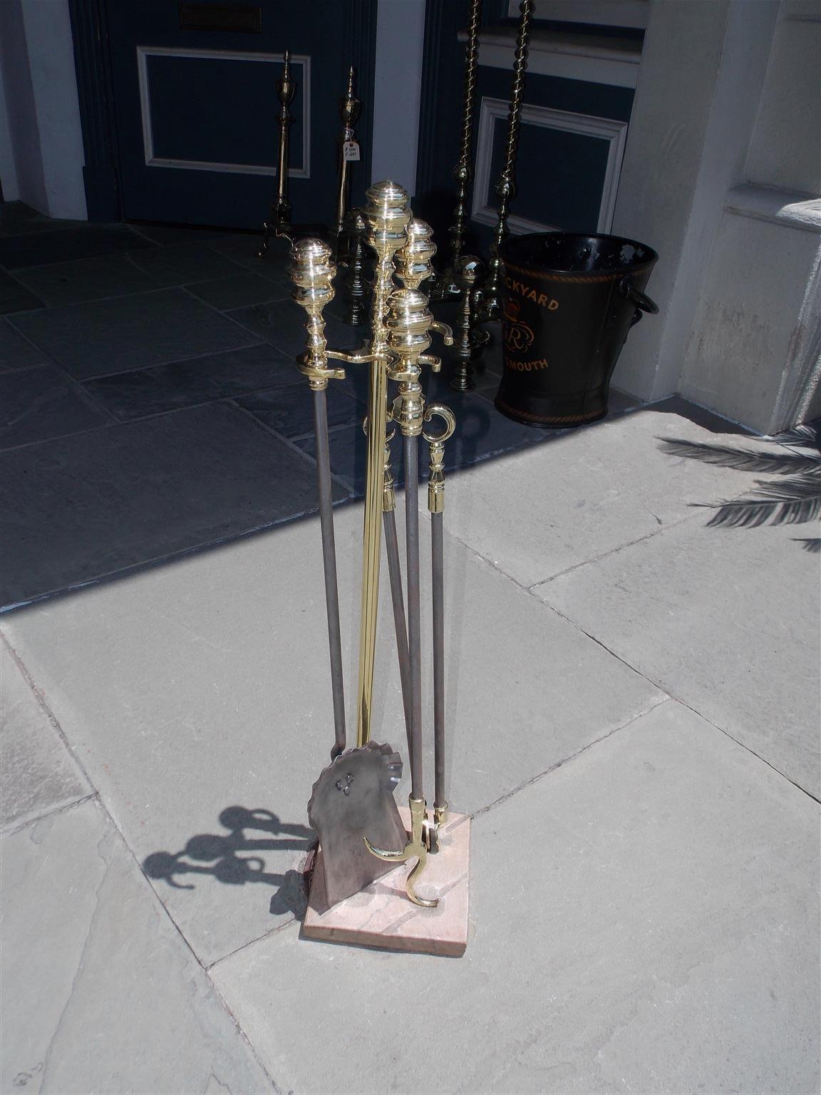 Set of American brass and polished steel fire tools on the original squared marble base stand with round depressions and slotted gouges. Early 19th century, Philadelphia. Stand finial and jamb hook are identical with tool finials and the set consist