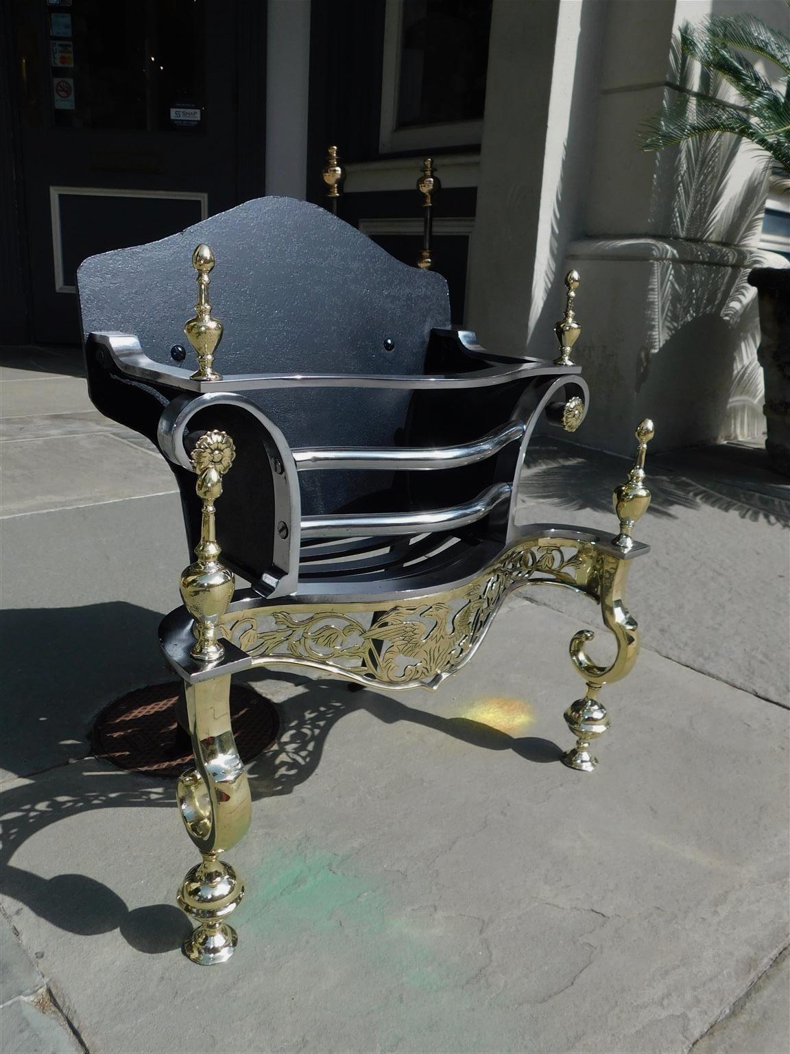 American brass and polished steel fire coal grate with flanking urn finials, floral medallions, hand chased foliage and eagle gallery, serpentine cast iron back, and resting on scrolled bulbous legs. Early 19th century.