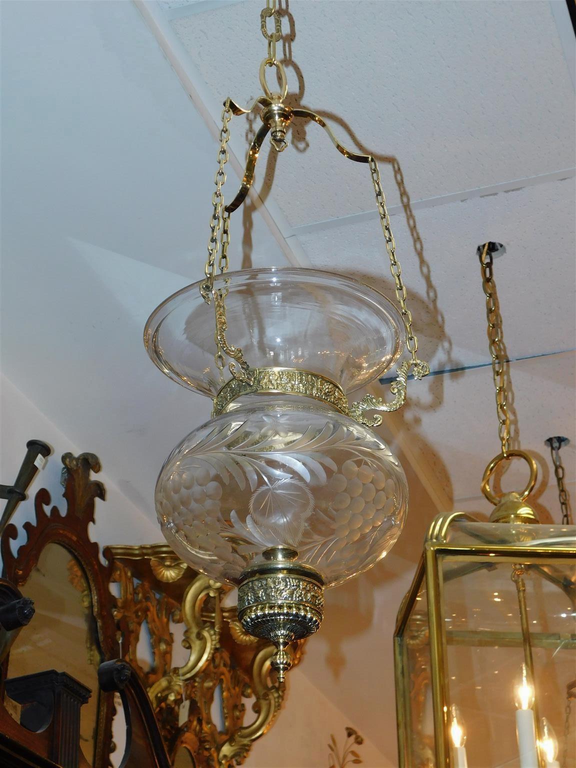 Lanterna americana a campana in ottone e vetro con fogliame inciso, con tre bracci decorativi a volute, motivo a vite e perline finali. Inizio del XIX secolo. La campana è alimentata a candela ma può essere elettrificata senza costi aggiuntivi.