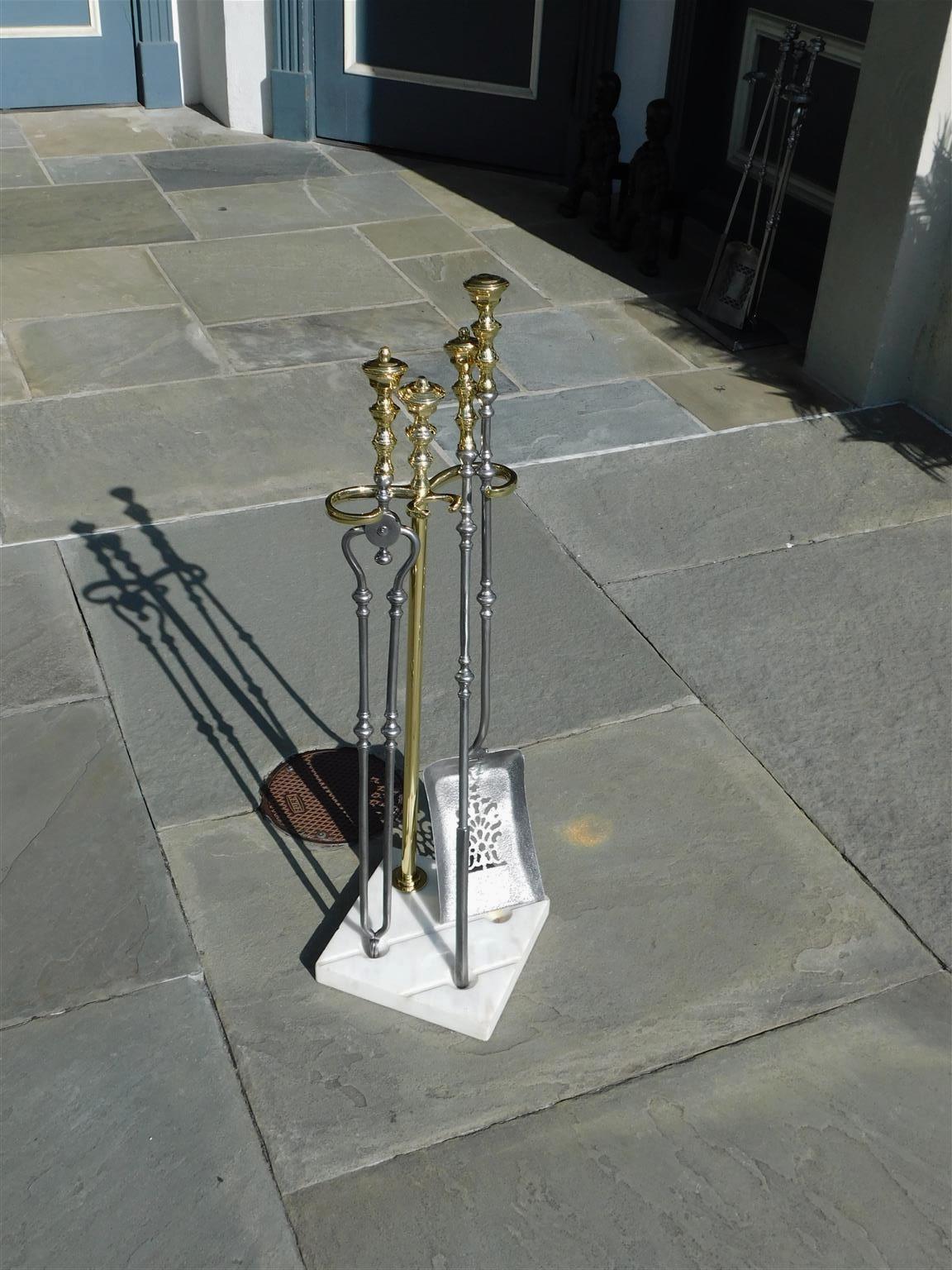 American brass finial and polished steel fire place tools resting on the original squared grooved marble stand, Early 19th century. Set consists of pierced shovel, tong, and poker.
