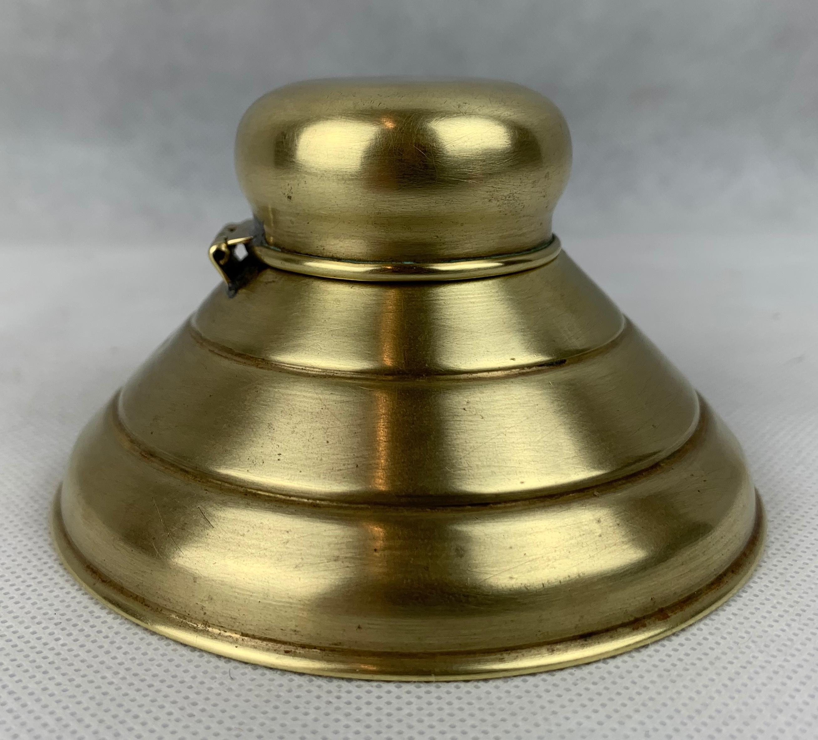 Futurist early 20th century American hinged brass inkwell. The domed top and three sectioned bottom gives this inkwell a surprisingly futuristic look almost like a flying saucer.
Polished by hand in our workshop.   (We go through the laborious task