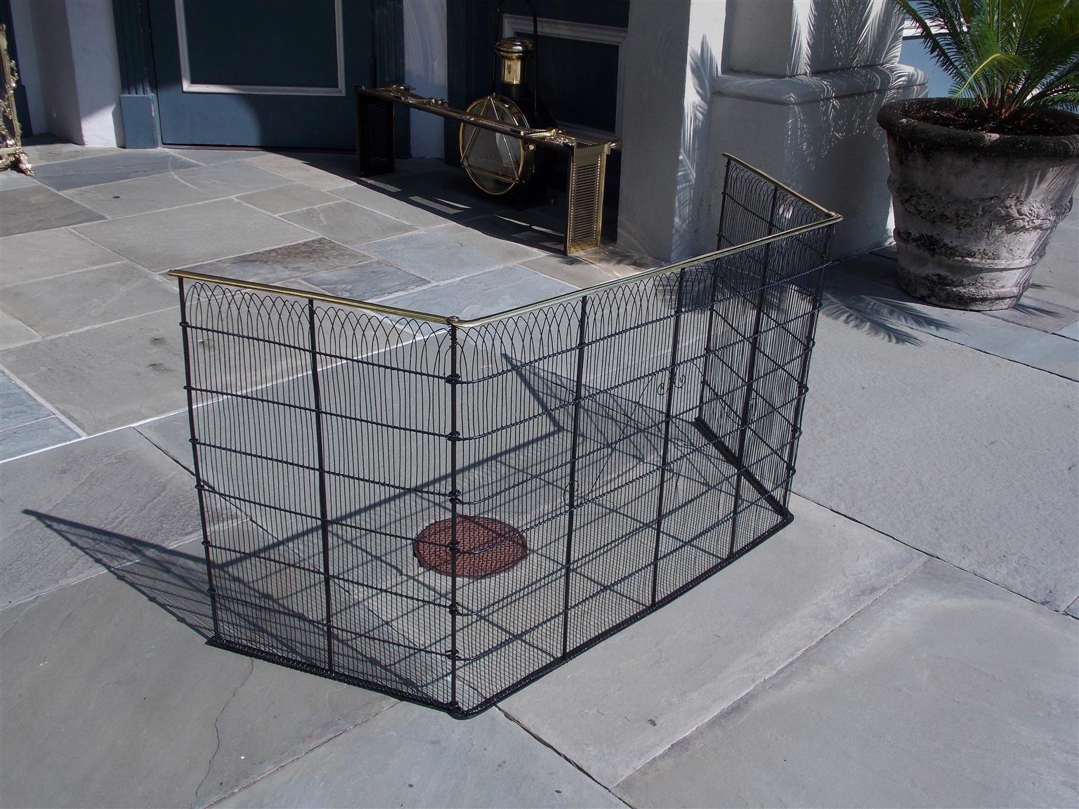 American brass rail top and pleasing wire work hinged folding fire place screen with flanking eyelet holes for attaching to surround, Late 18th century.