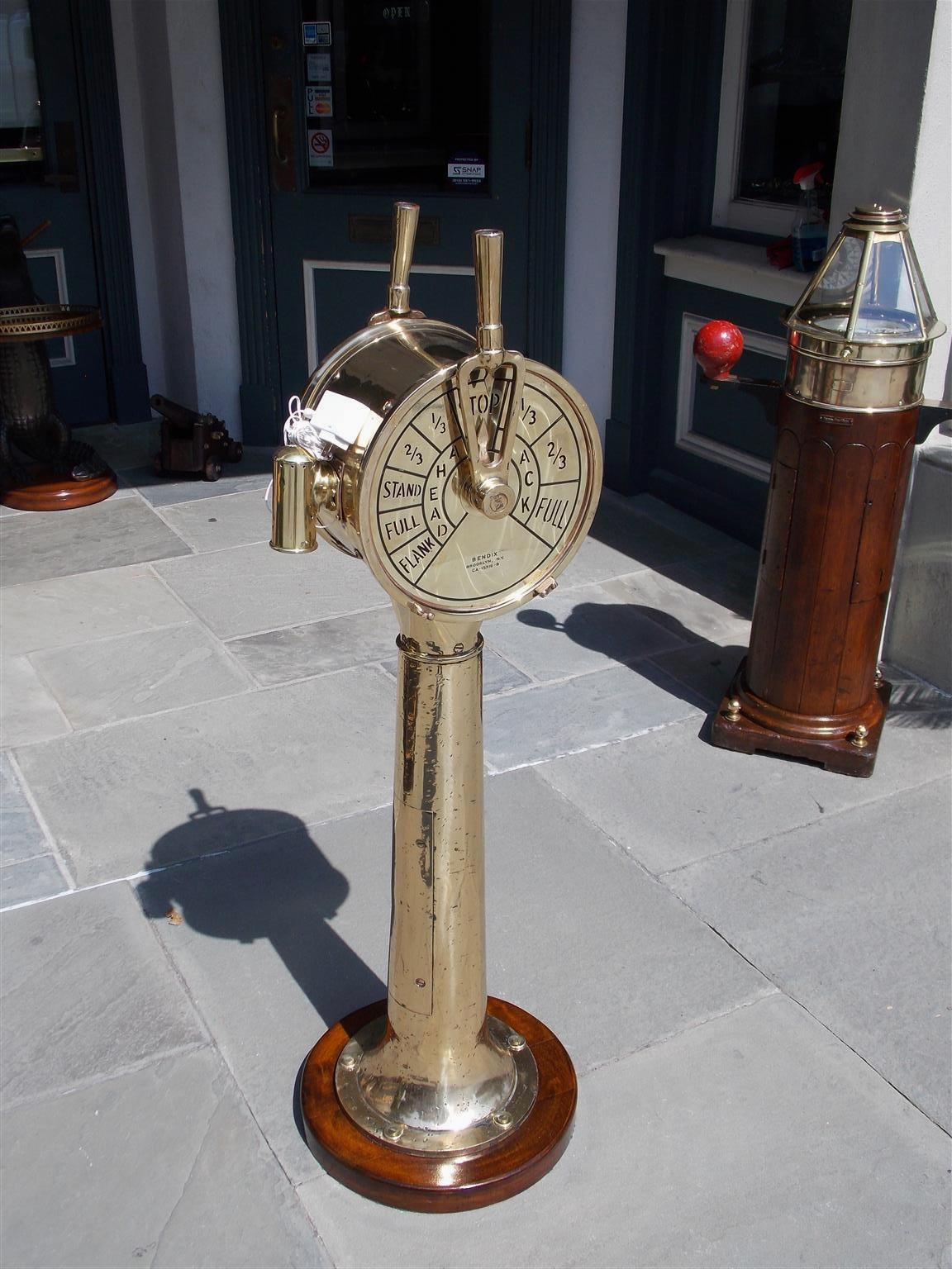 American brass ship's double engine order telegraph mounted on circular mahogany base.  E. O. T. has been electrified and has a faint bell ring when changing positions. Bendix Corporation, Brooklyn, NY. Model # CA-15316-B. Early 20th century.
