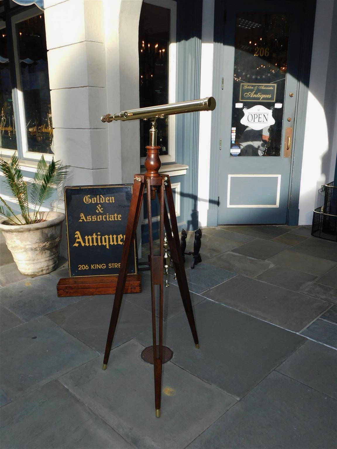 American brass telescope on adjustable walnut tripod stand. Telescope retains the original glass lens, traveling dovetailed case, and lens cover. Telescope is all original and in working condition. Tripod legs are 31
