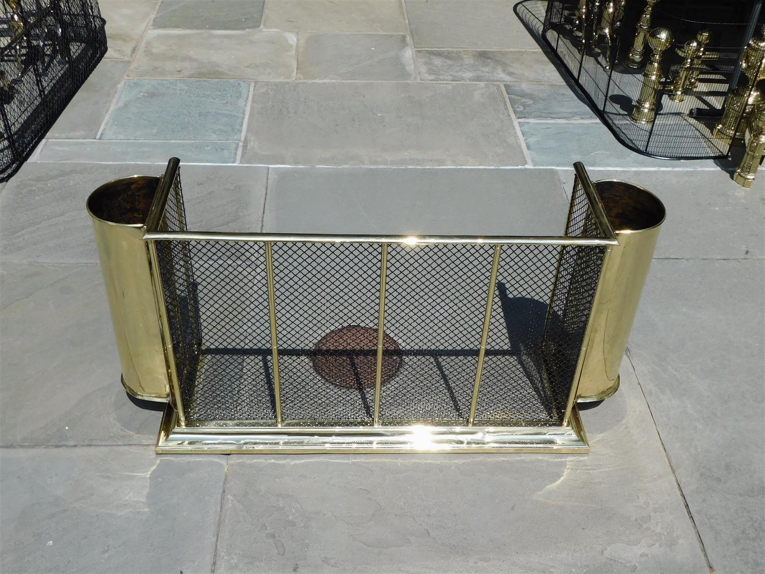 American brass and wire fire place fender with flanking canister tool holders resting on a step back molded edge base, Mid 19th Century
40.75