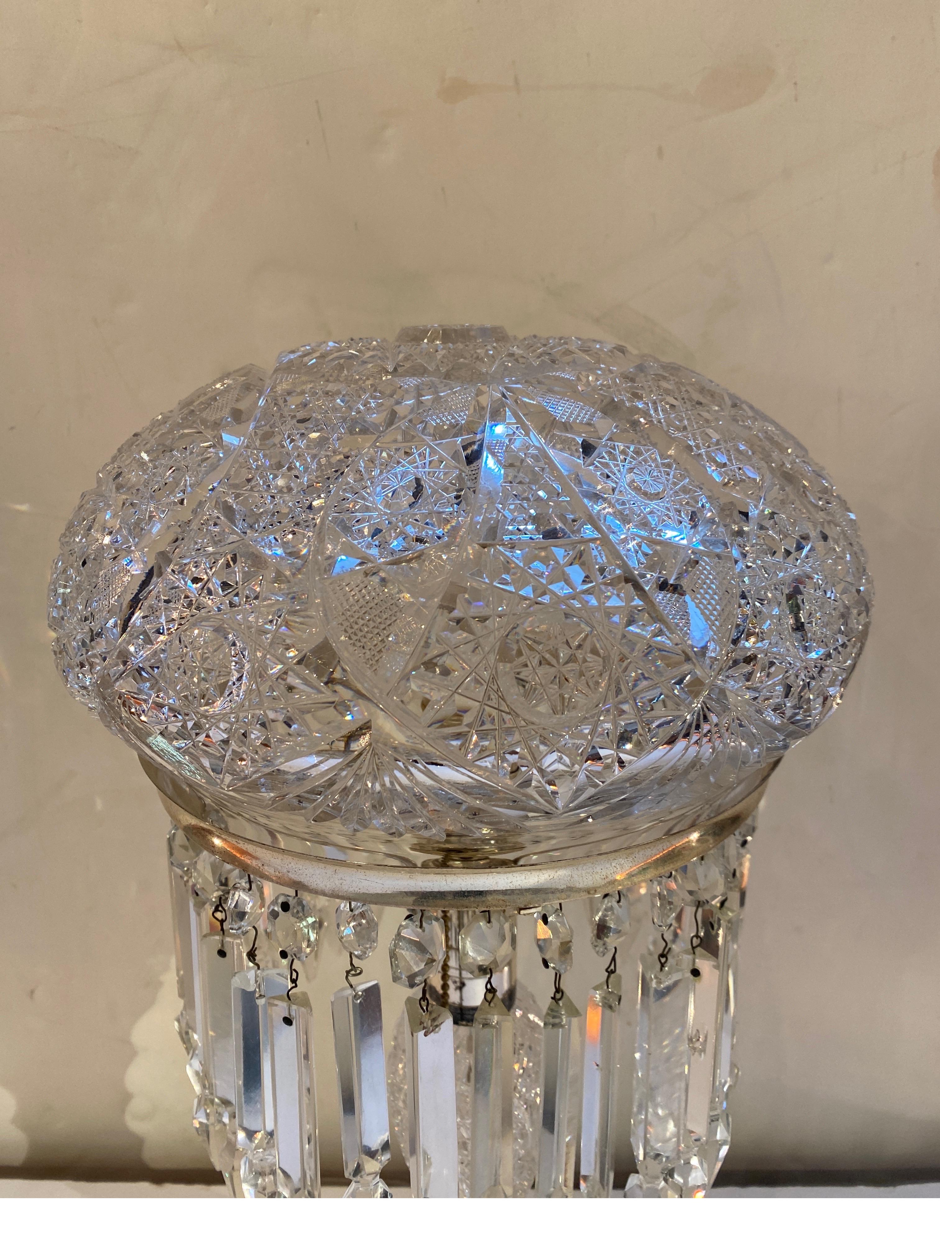 Elaborately cut American Brilliant glass table lamp. The base and shad are original with all around spear hanging crystals. The mount is silver plate and take a standard light bulb. The is 100% all hand cut and polished by a master cutter on a wheel.