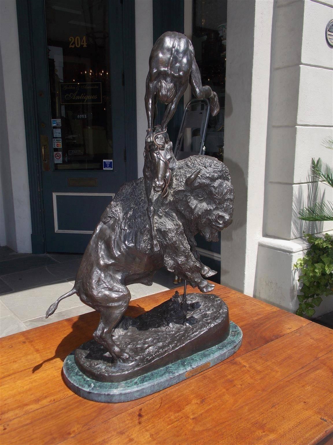 American Re-strike bronze sculpture of Buffalo horse resting on an oval Italian marble base. A native American hunter is depicted attempting to overpower and take down a powerful buffalo. The buffalo comes up under the horse and throws the hunter up