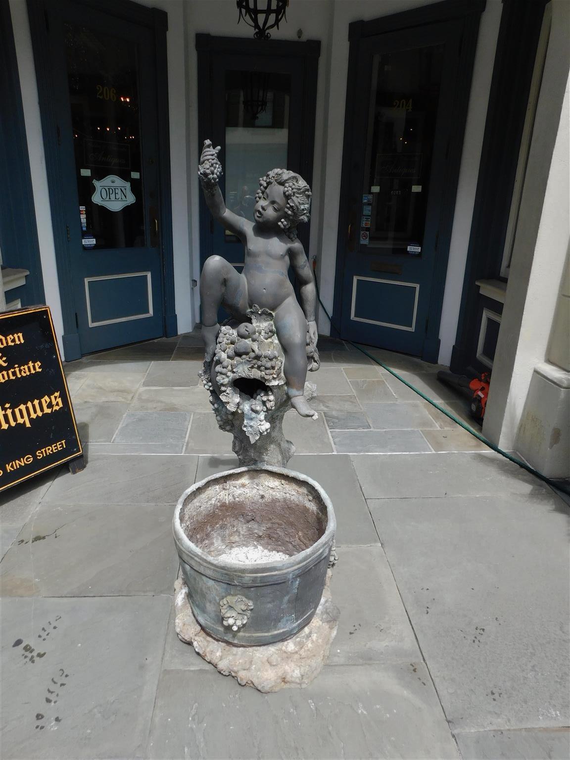 Amerikanischer Bronze und Blei sitzende Figur junger Bacchus Gartenbrunnen mit dekorativem Traubenmotiv und fließendem Wasser in unteren Weinfass. Der Brunnen ist auf dem Sockel vom Hersteller signiert und mit einem internen Kupferrohr versehen.