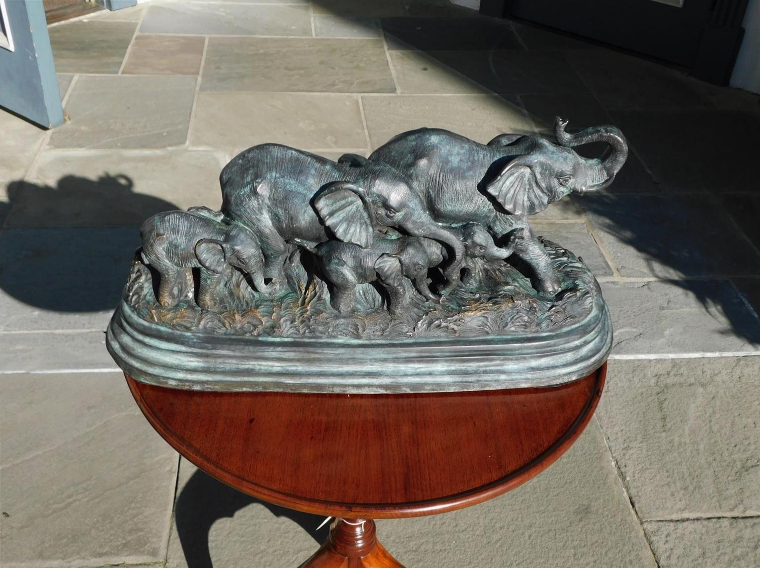 American bronze oval elephant herd sculpture resting on a molded edge base, 20th Century.