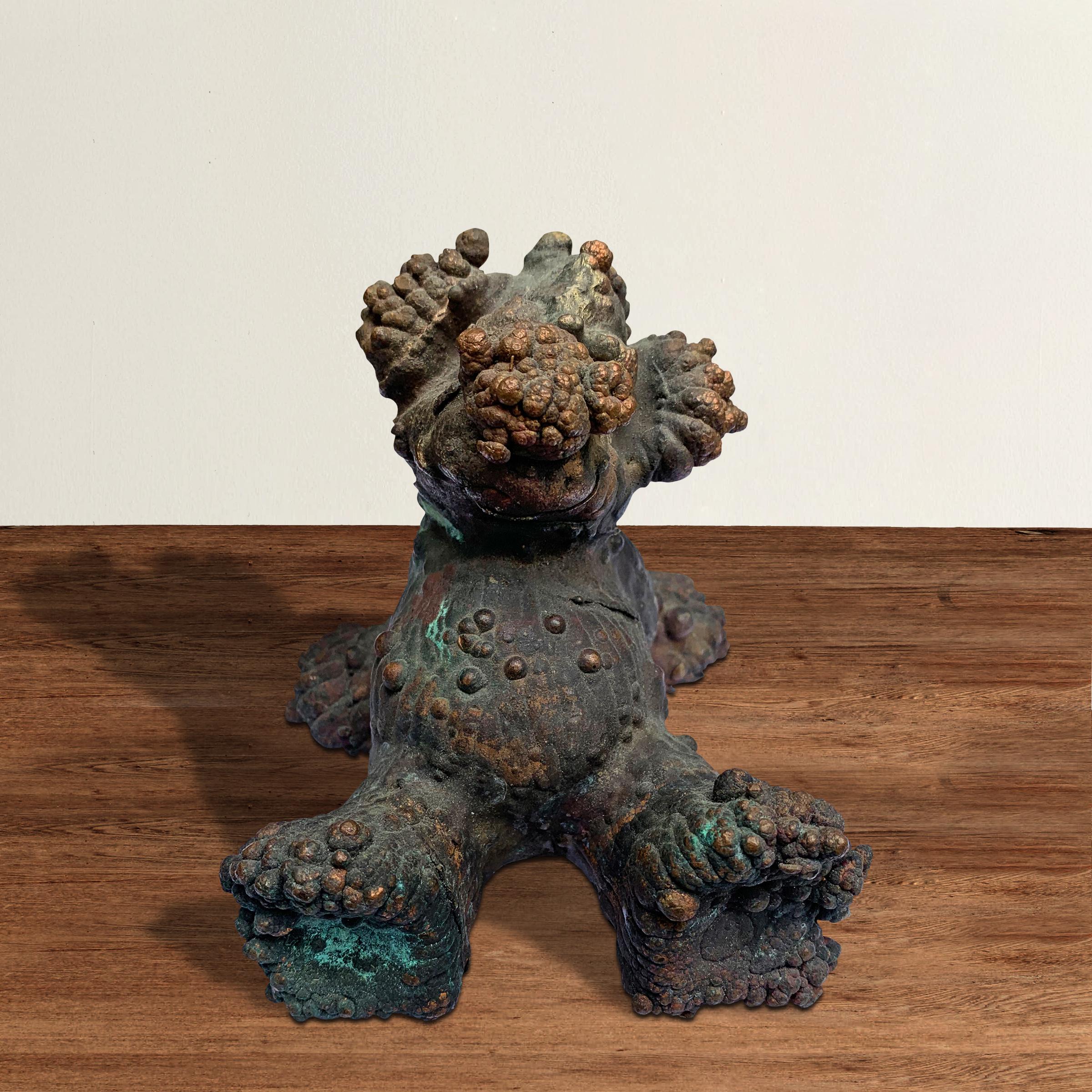 A whimsical and charming American bronze toy, or possible dog toy, mold depicting a lounging bear or monster with a fantastic variegated patina.