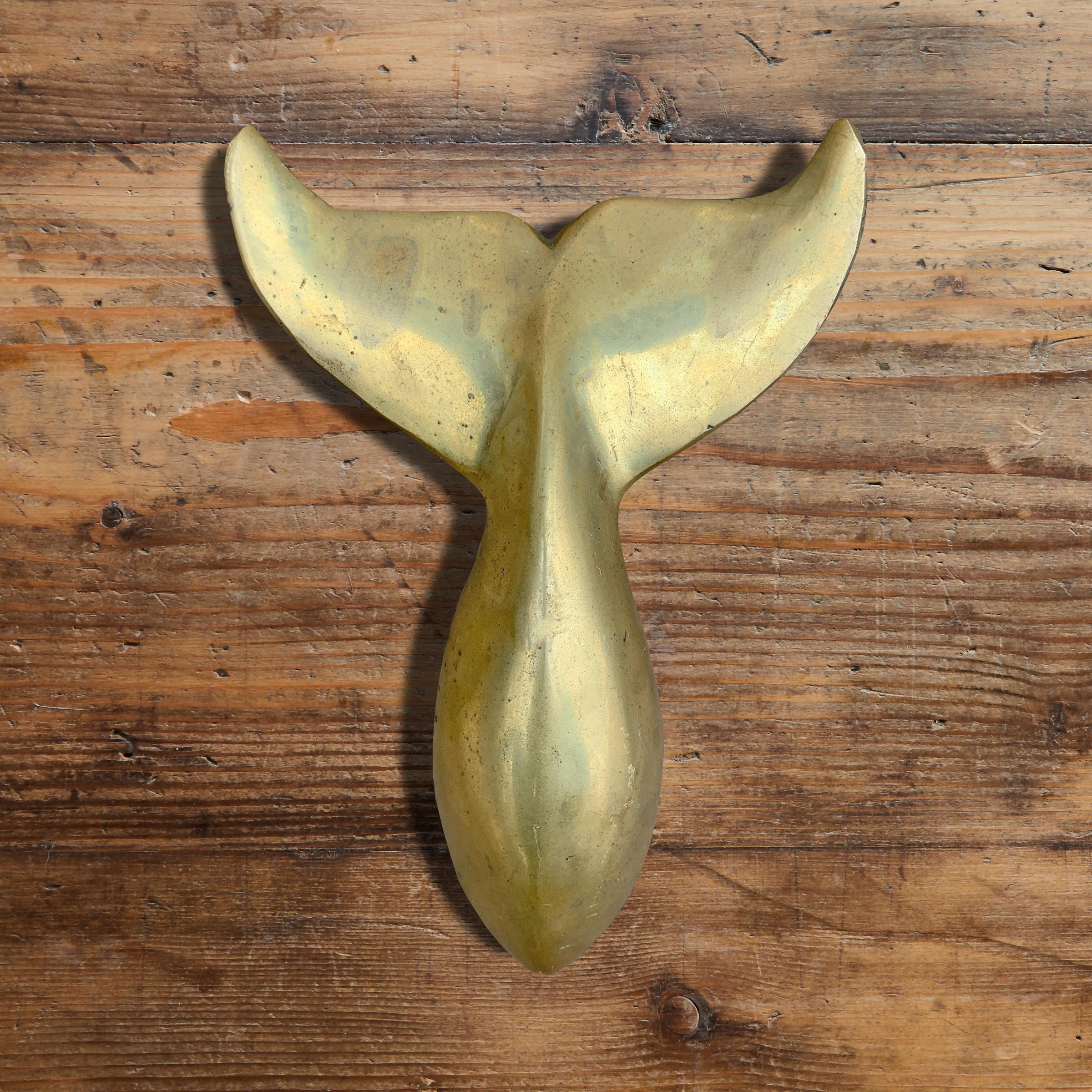 A beautiful sculptural mid-20th century American cast bronze whale tail doorknocker with a heavy hand and a wonderful patina.