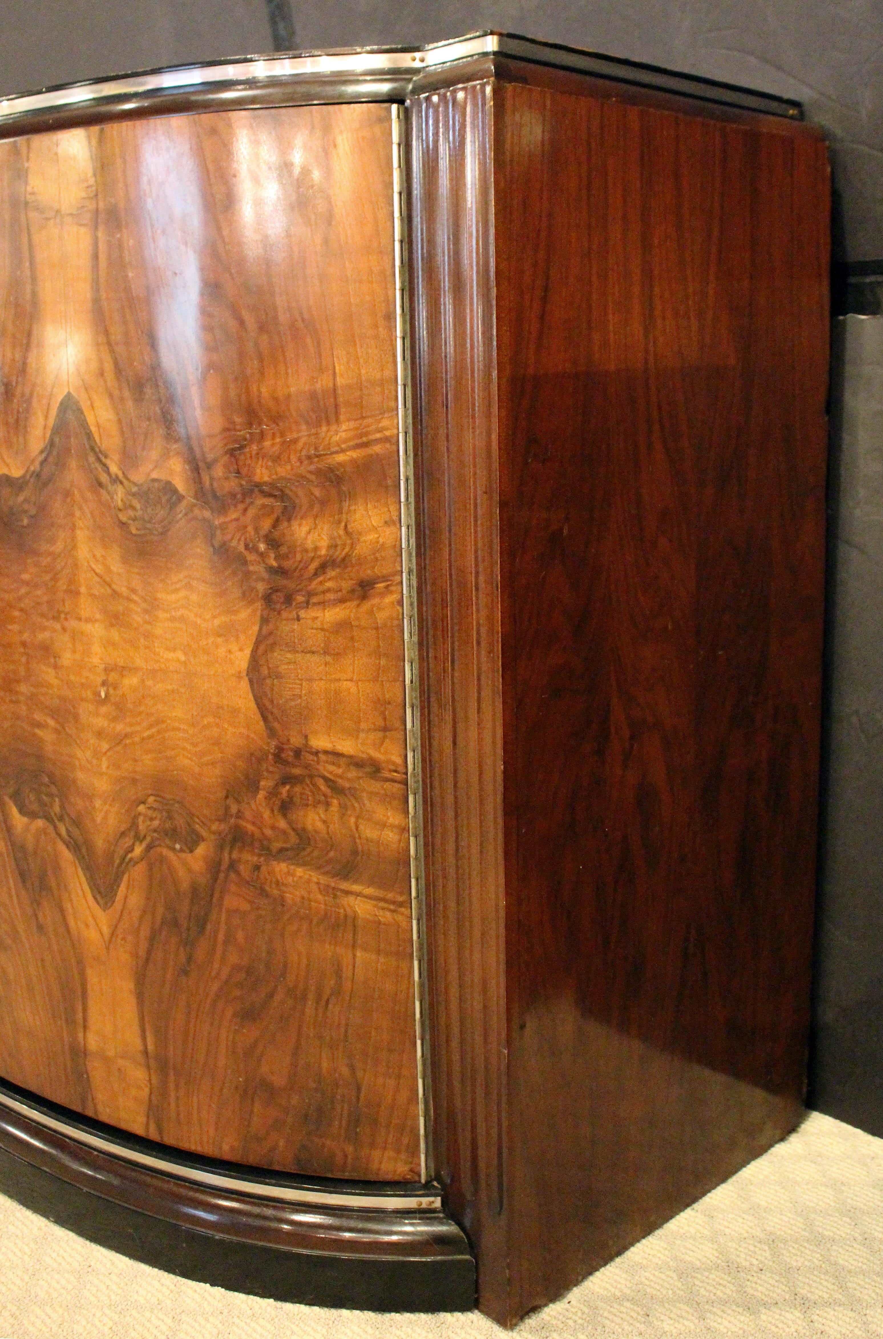Art Deco period Walnut Credenza Sideboard or Bar by West End Furniture Co., USA. Circa 1930 Art Deco credenza of stunning burl walnut & walnut in sensual undulating design of the period. Retains all period chrome pulls & hardware with ebonized trim.