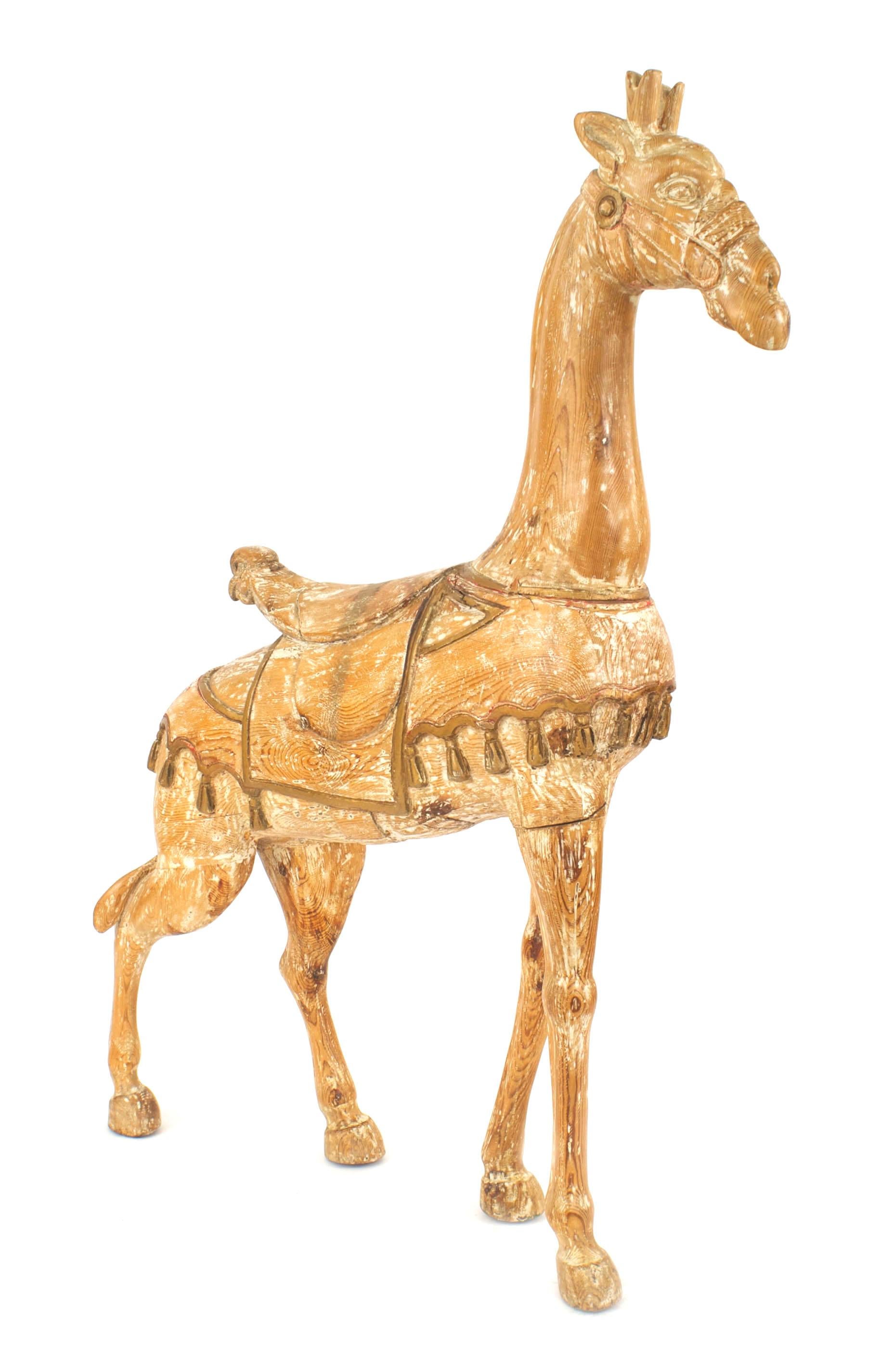 American carousel style (20th Cent) of stripped pine large giraffe figure with gold trim and wearing a saddle
