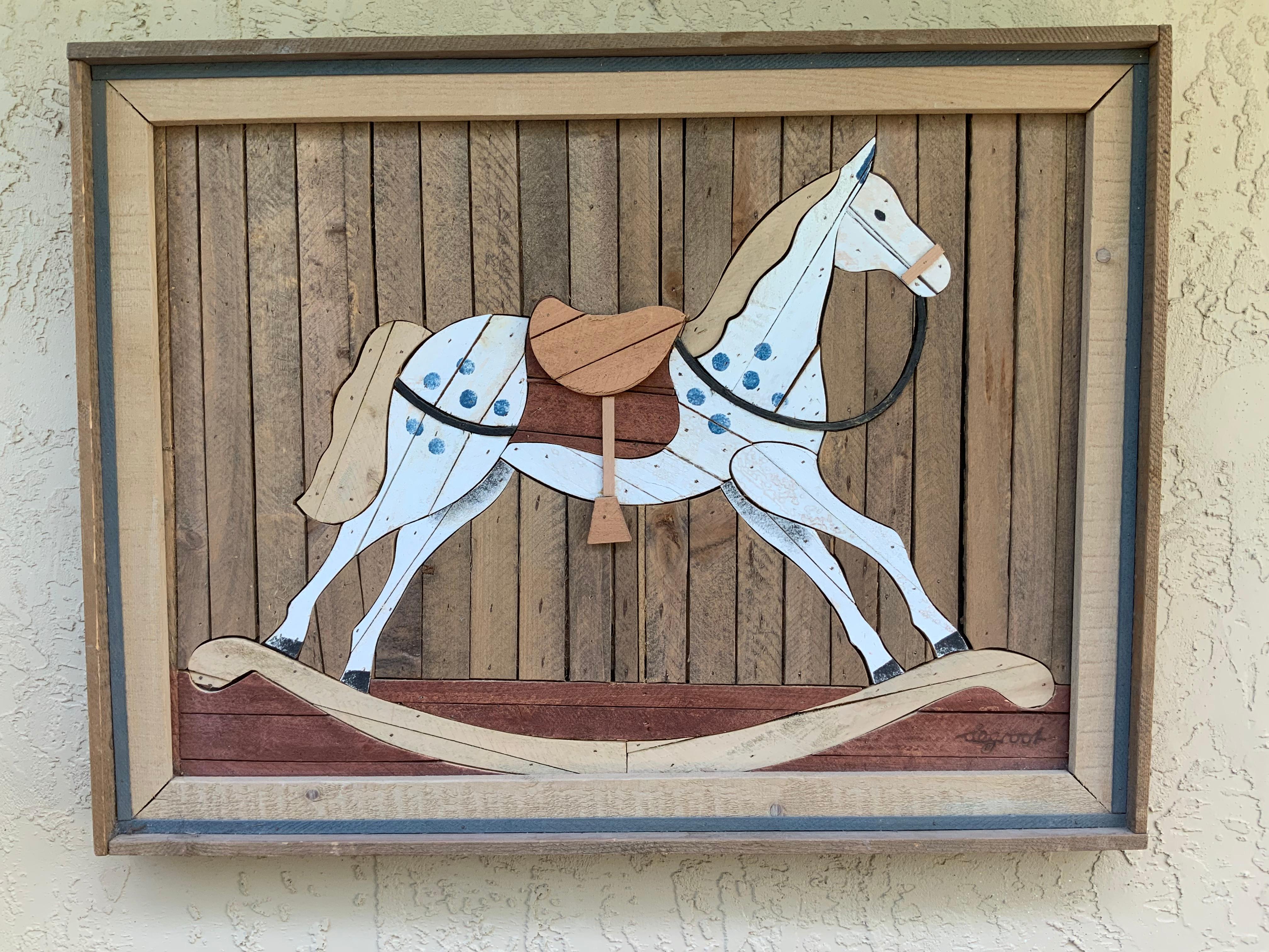 Beautiful wall hanging made of carved wood, hand painted mosaic pieces of wood depicting
A children’s rocking horse, rustic, countryside.
Artist signature bottom right.