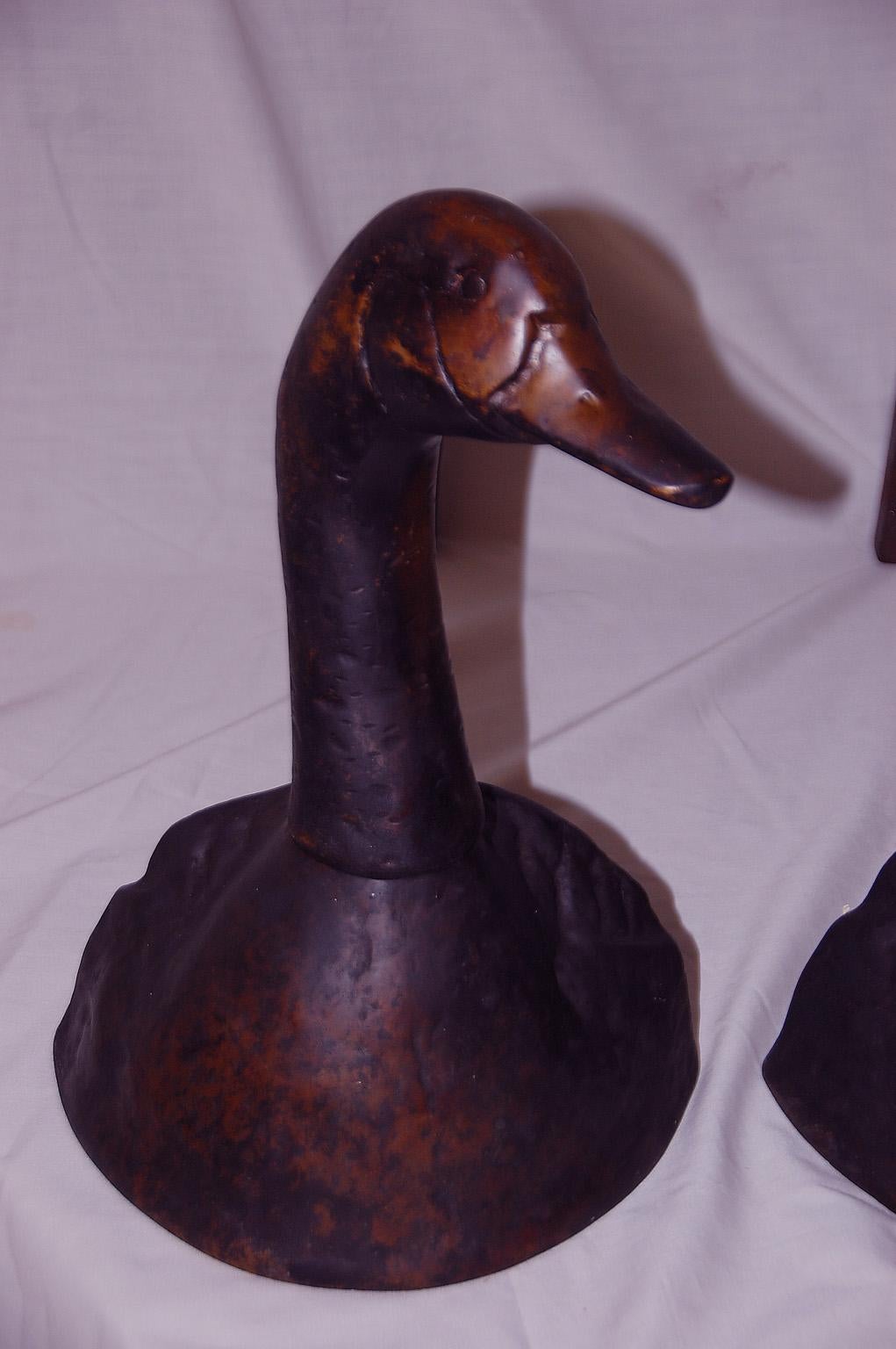 American cast brass duck andirons with heads that rotate to desired position. These exceptionally heavy and rare andirons have never been polished and retain a lovely soft patination. If the purchaser wanted them polished to a bright brass finish,